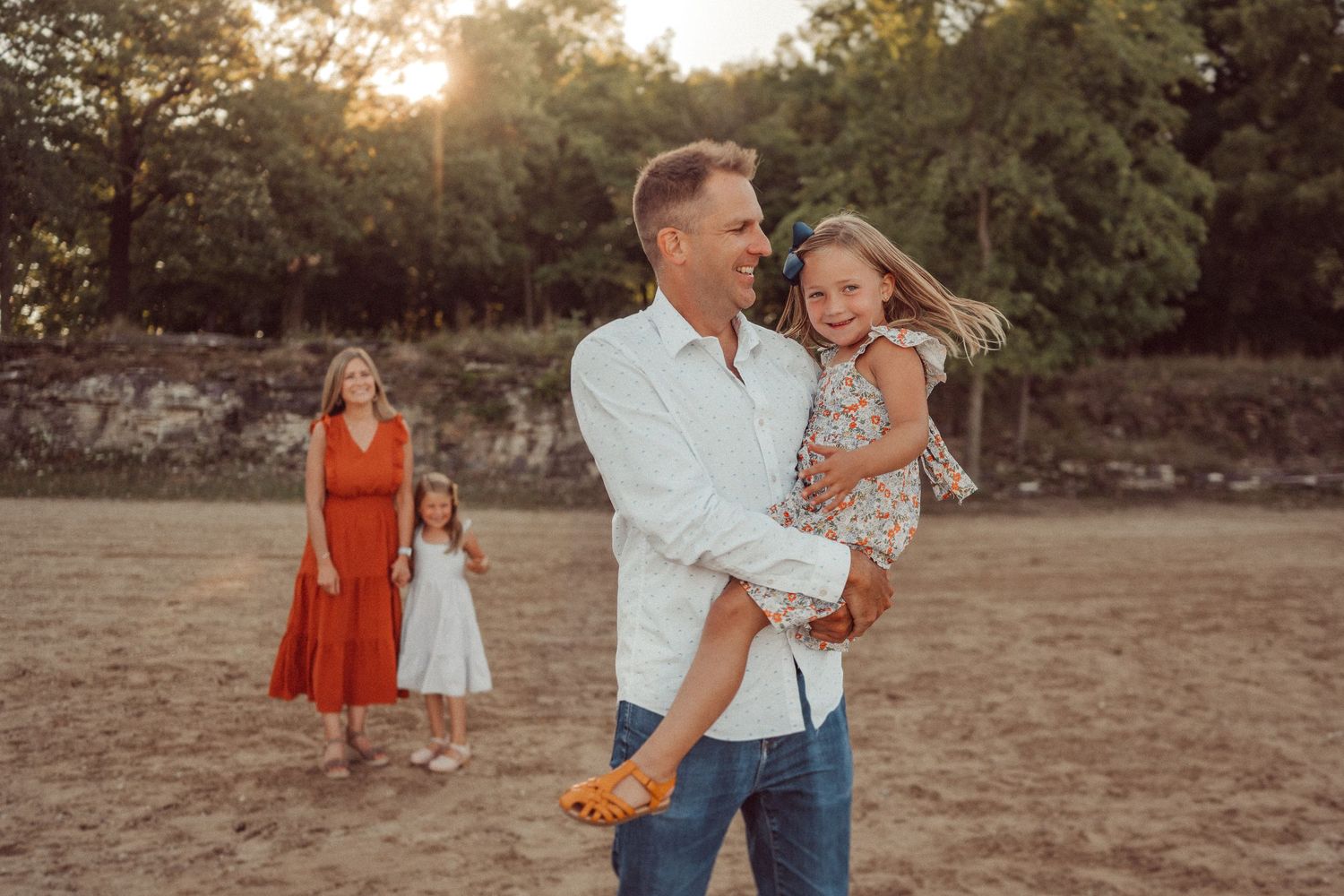 A family spending time together at sunset with a stone wall backdrop.
