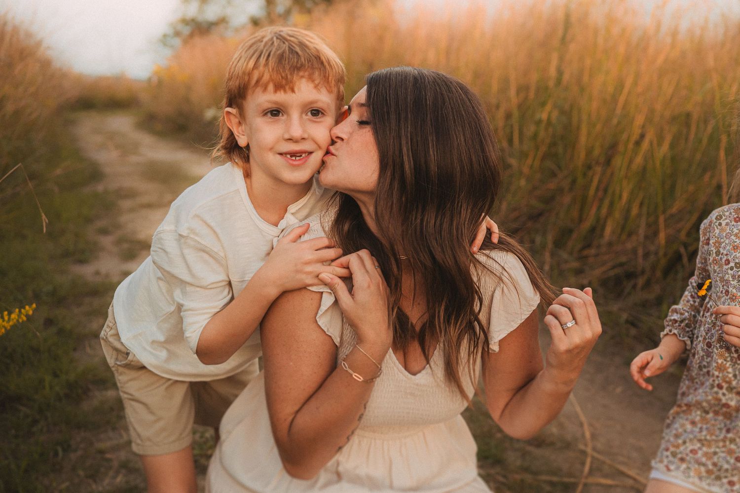 Family enjoying a tender moment together in golden field at sunset.