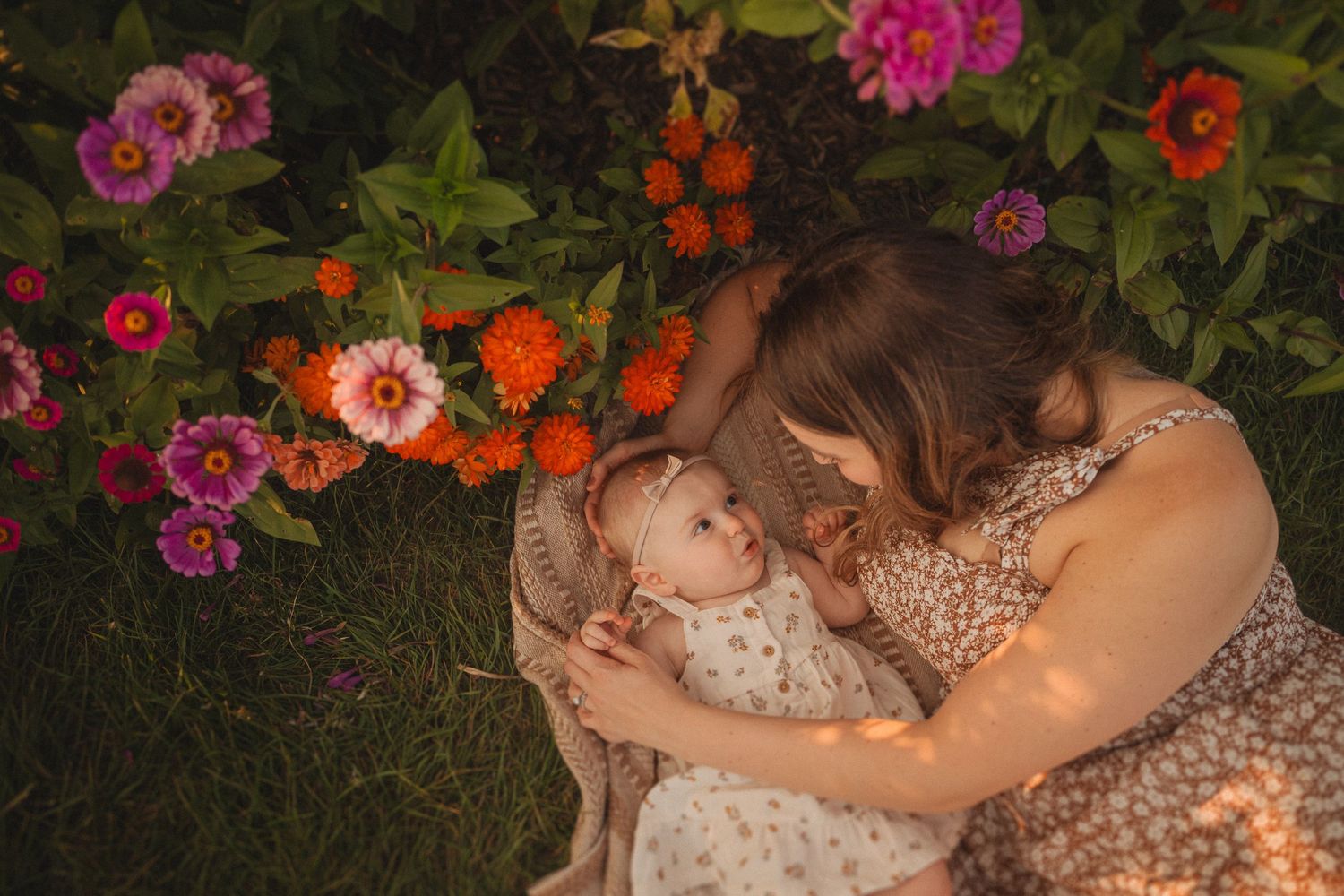 Intimate portrait in garden setting surrounded by pink and orange blooms at sunset.