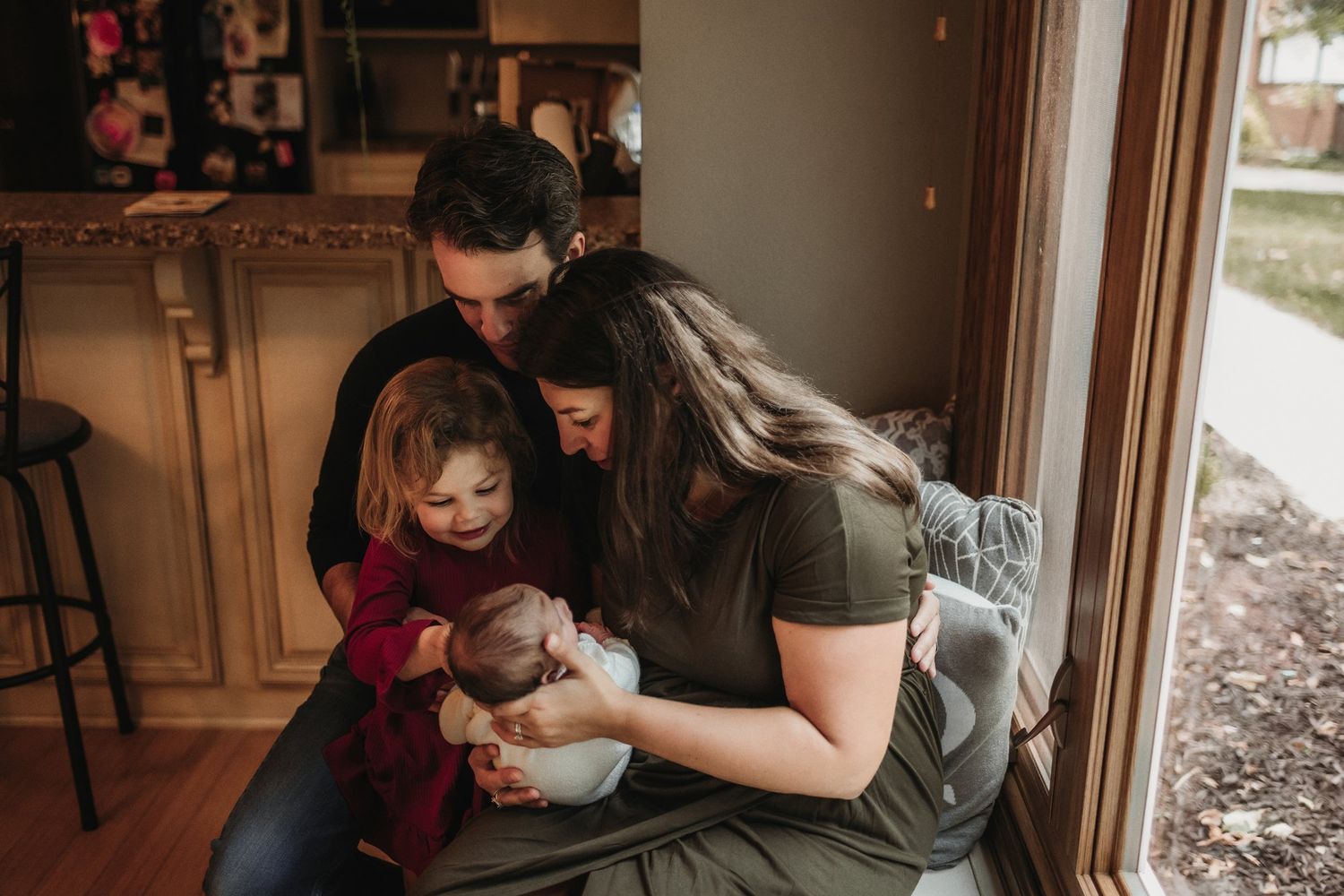 Family gathered by window sharing a special moment together in natural light.