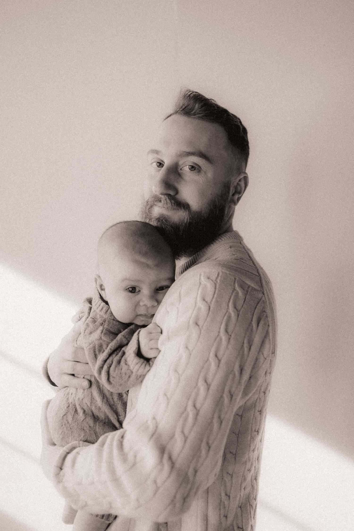 Tender black and white portrait series featuring cable knit sweaters and soft lighting.