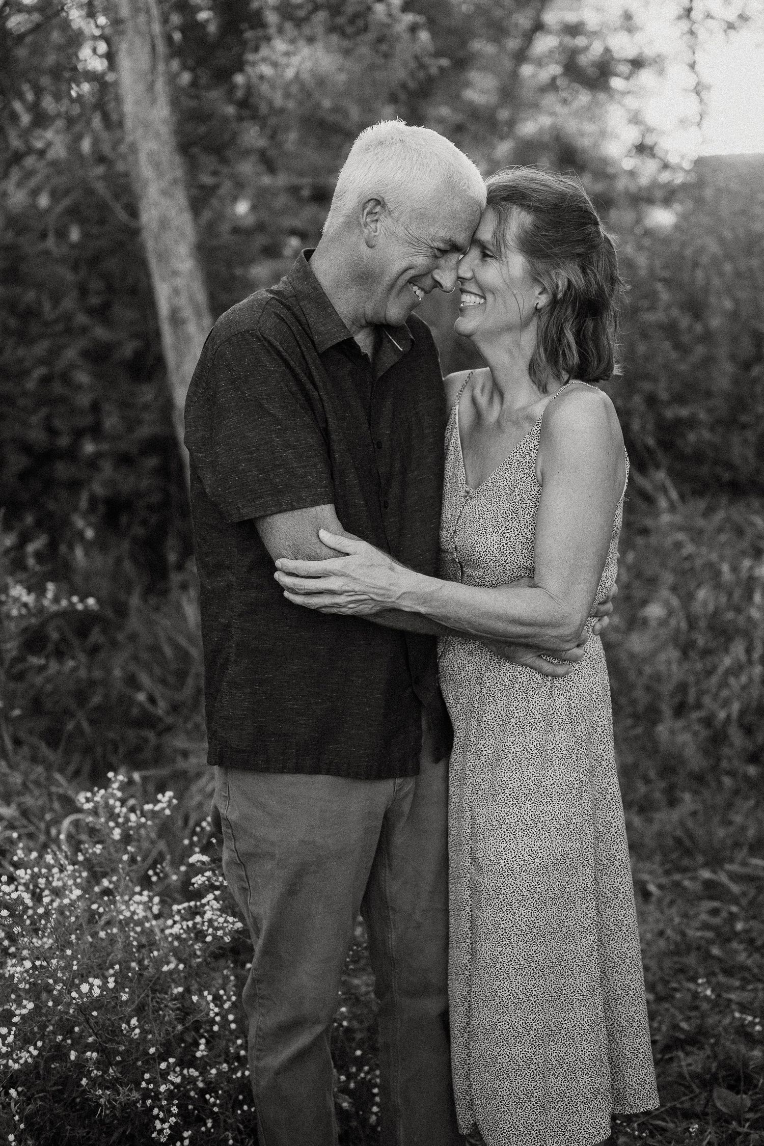 Romantic black and white photos show intimate moments between a couple in a garden setting at sunset.