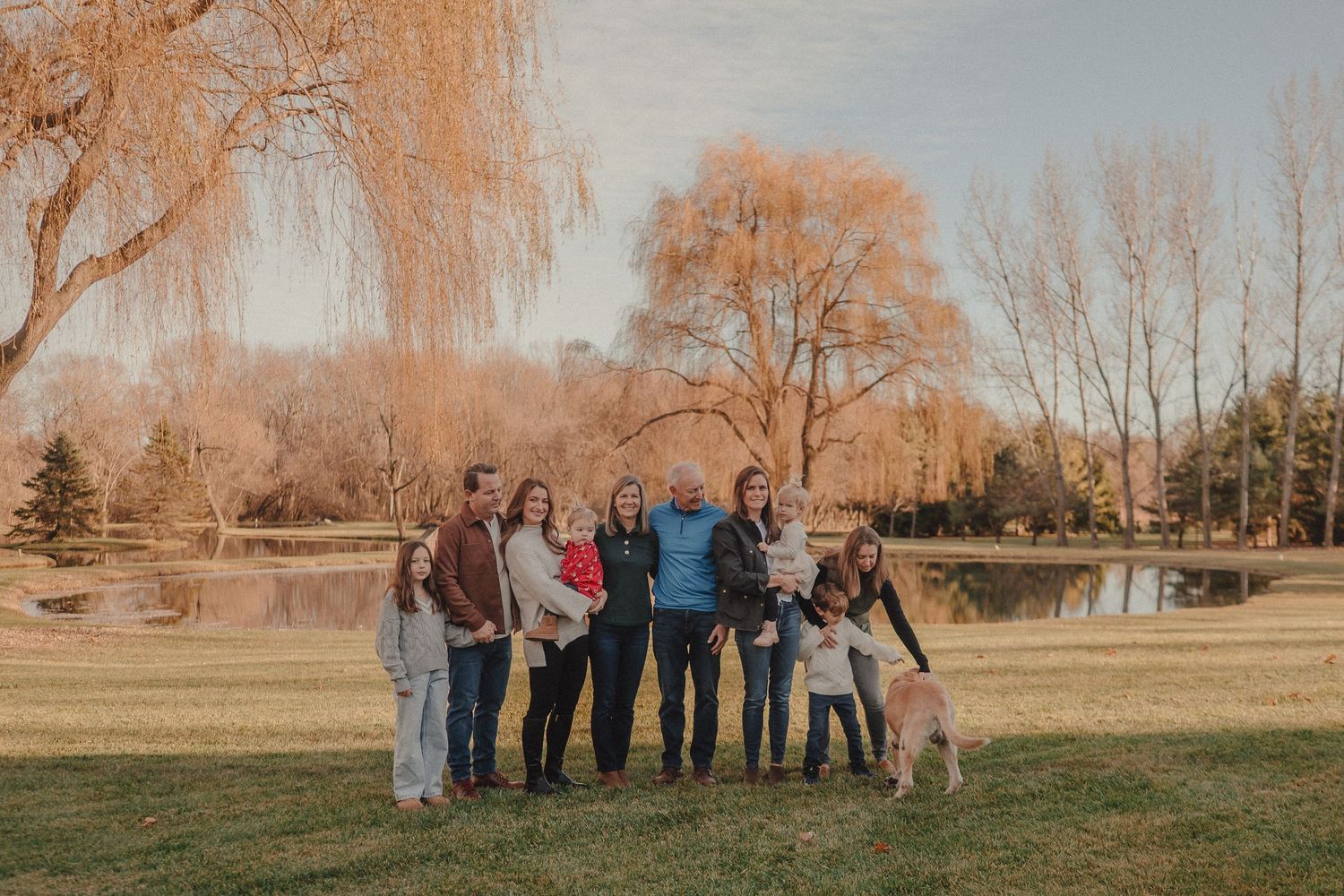 Group photo of people standing together outdoors with autumn trees in the background.
