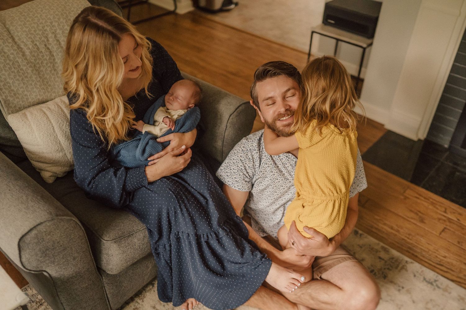 Natural light candid family photos capturing tender moments on hardwood floors.