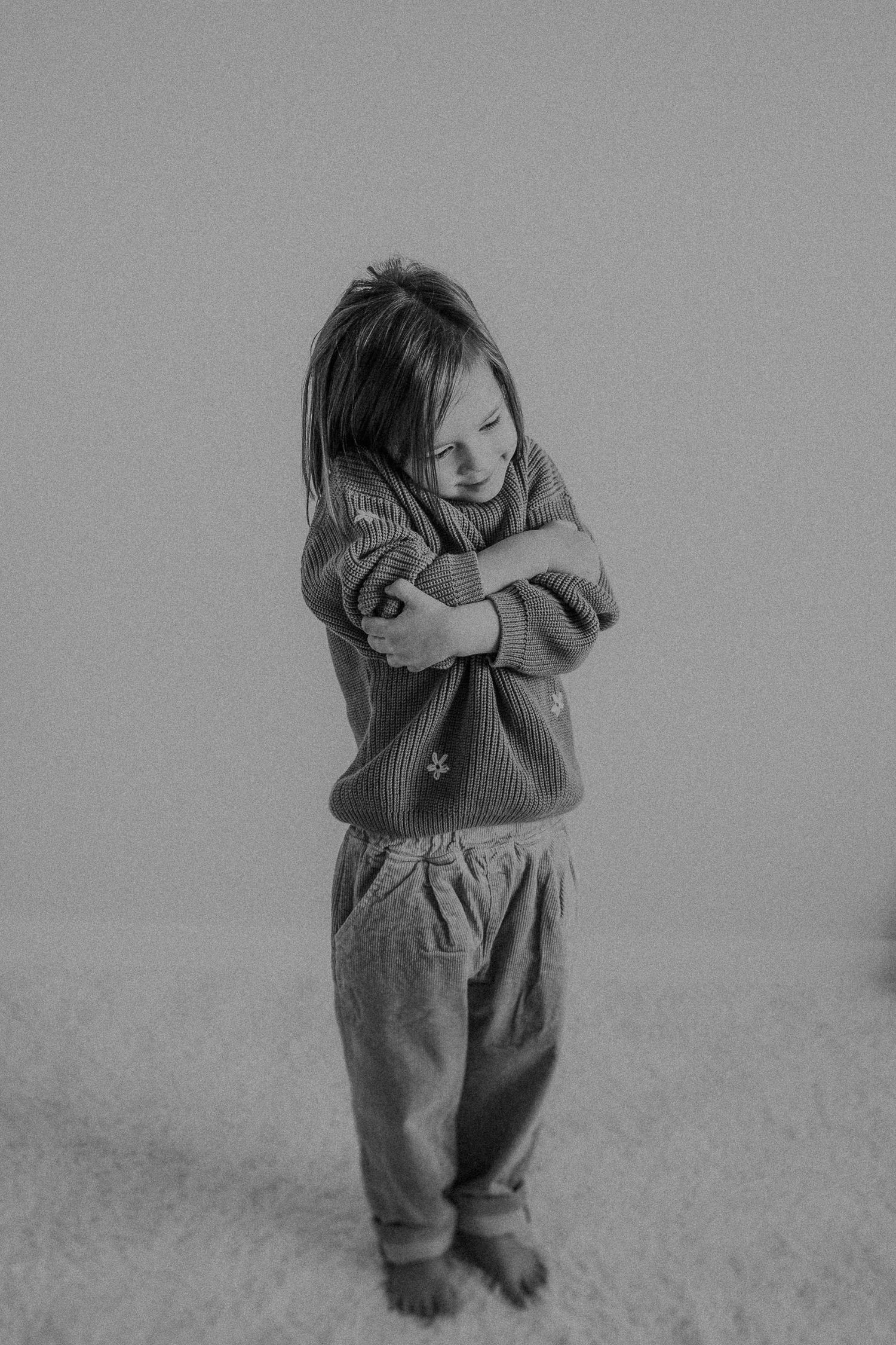 Moody black and white portrait with crossed arms showing attitude in casual wear.