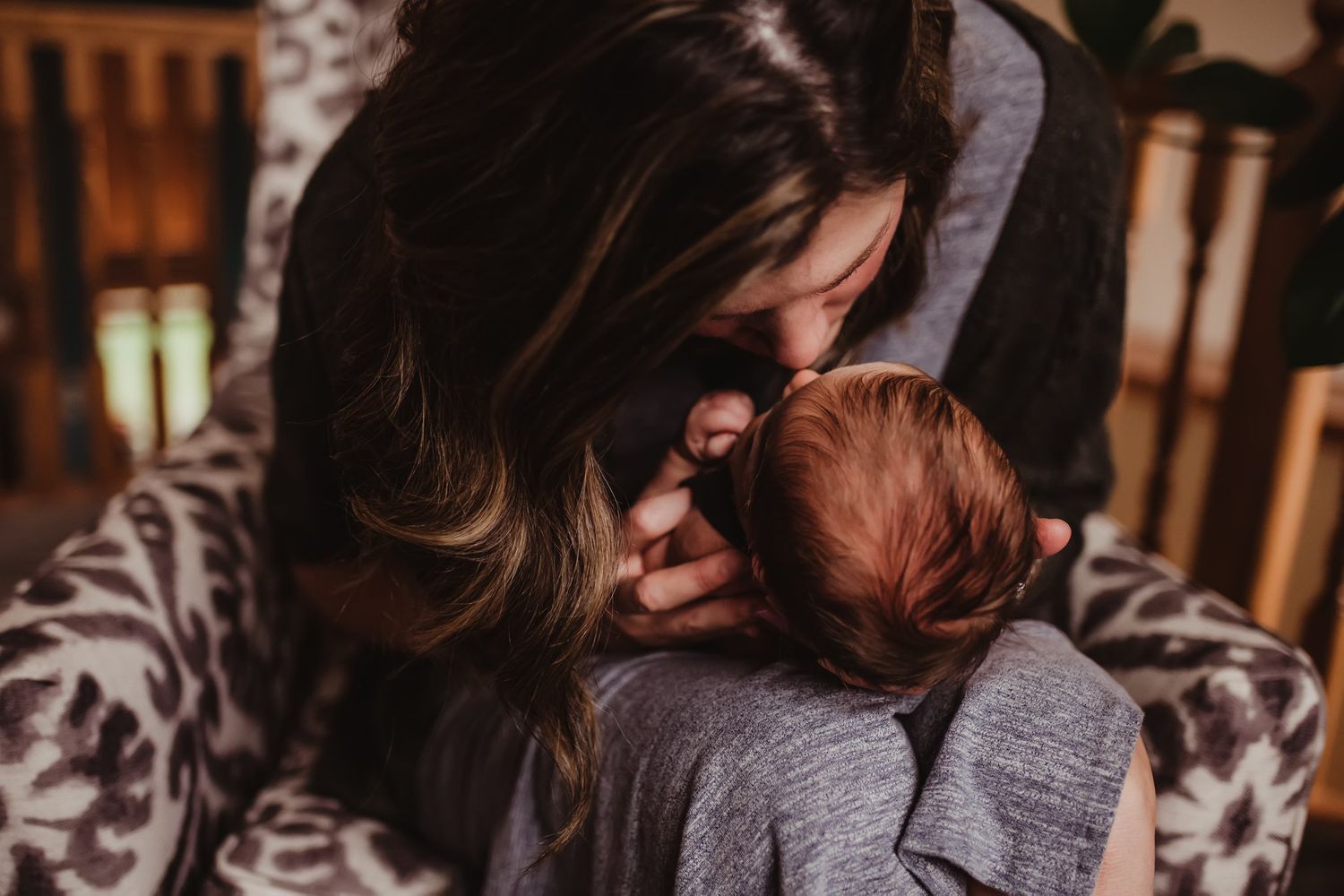 An intimate black and white portrait shows a quiet moment between parent and infant.