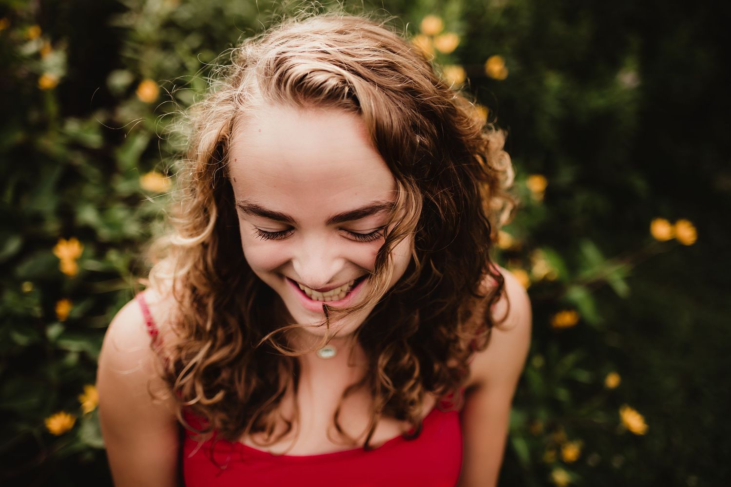 Candid close-up portrait with natural lighting and wildflowers in background.