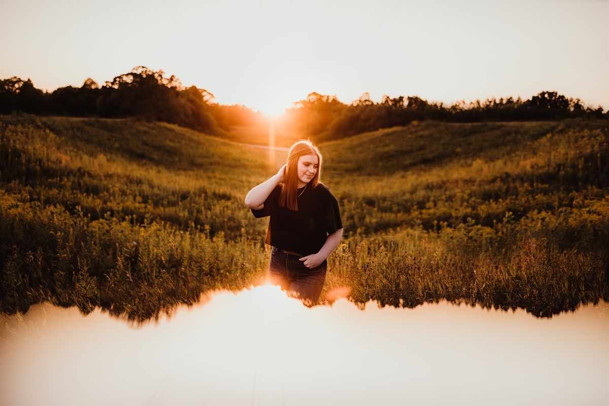 Artistic sunset portrait with water reflection in golden field.