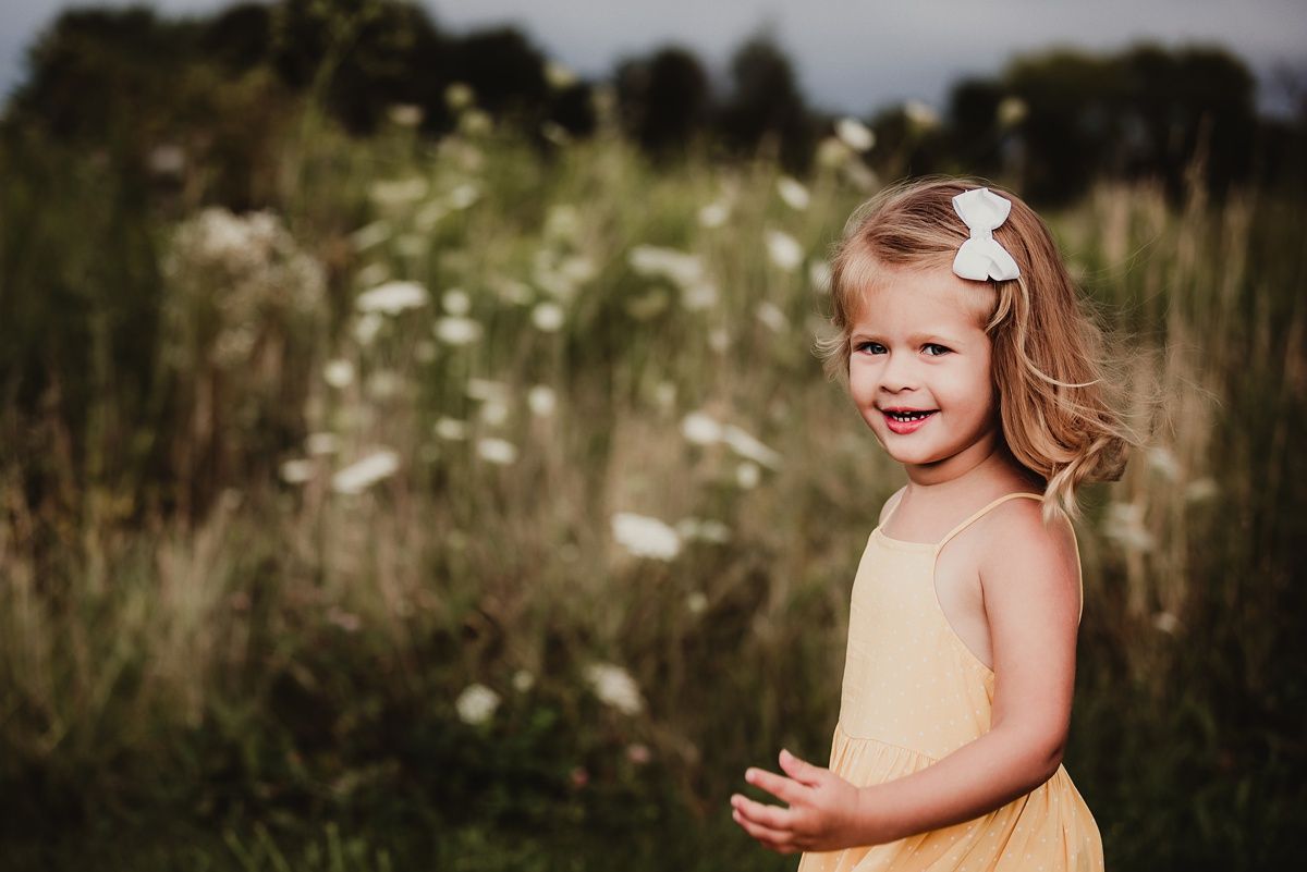 Portrait in a summer meadow with queen anne's lace flowers in the background.