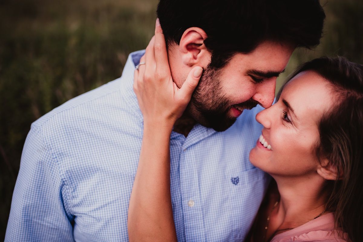 An intimate close-up of a couple sharing a romantic moment outdoors.