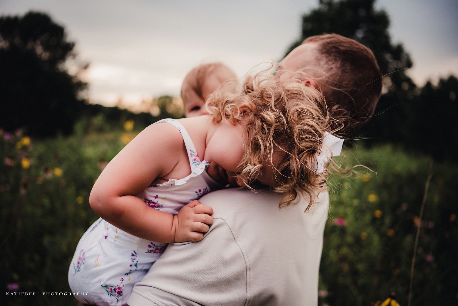 A tender moment captured in a wildflower field at sunset.