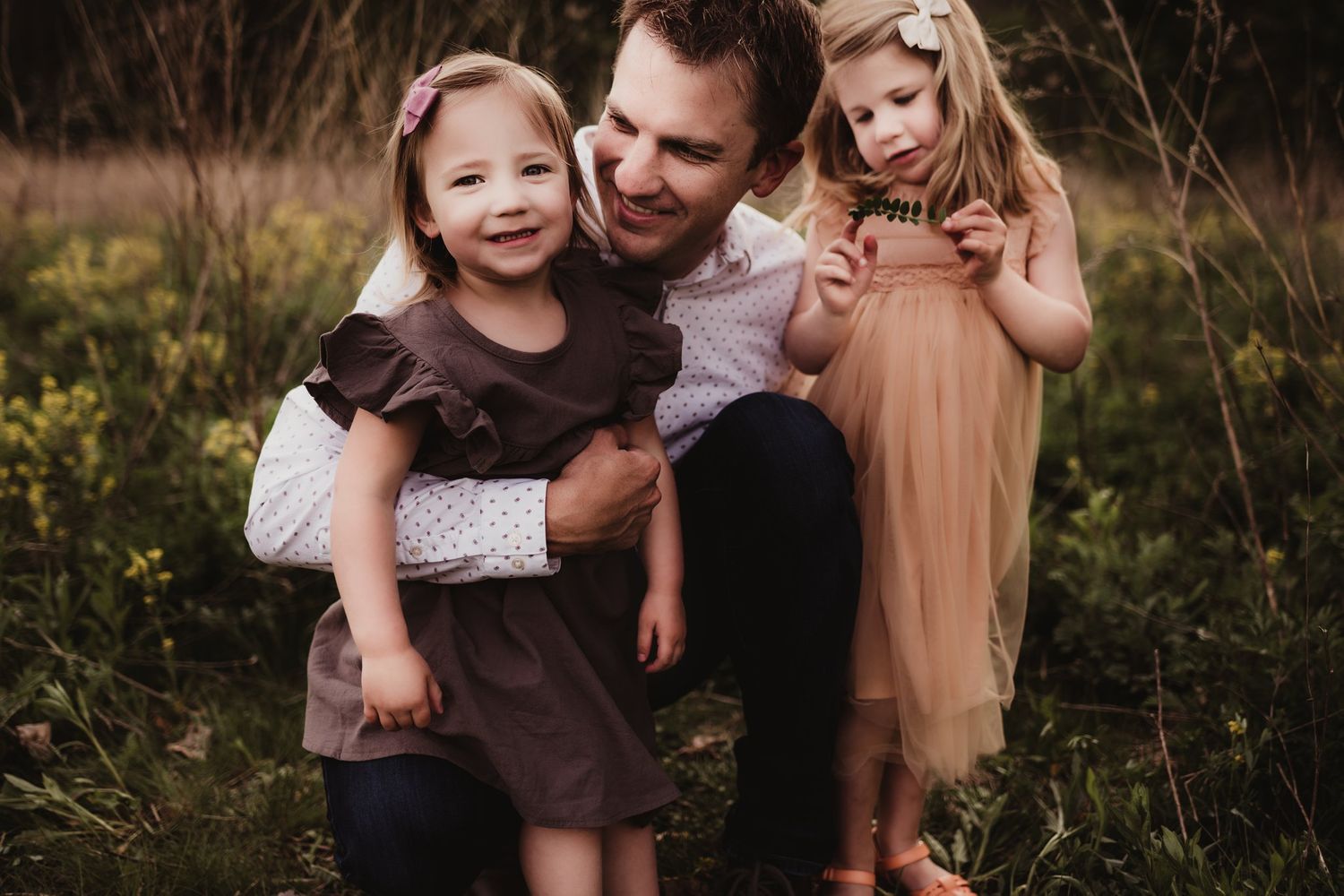 Candid family moment in a wild meadow wearing coordinated casual attire.