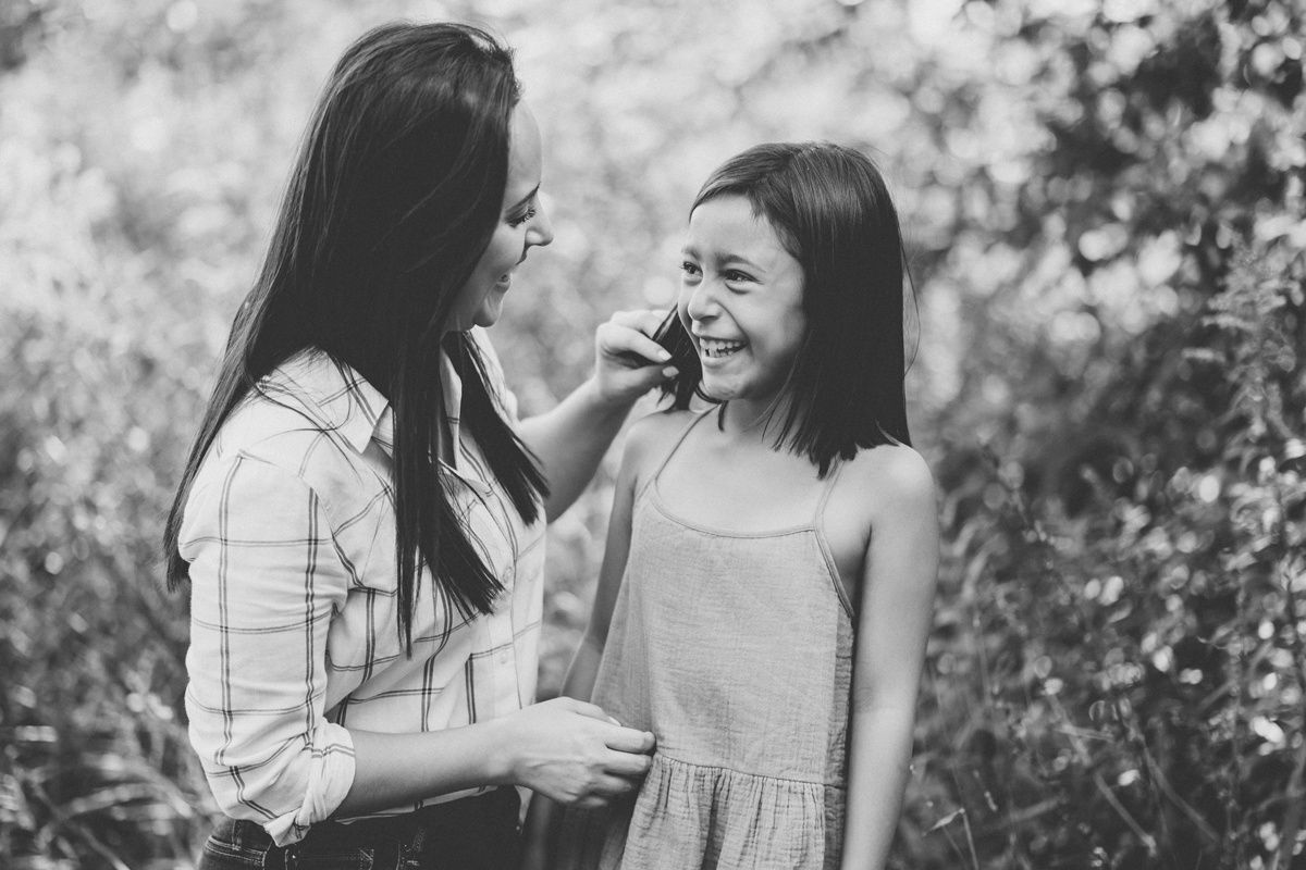 Black and white portrait capturing playful interaction between parent and child.