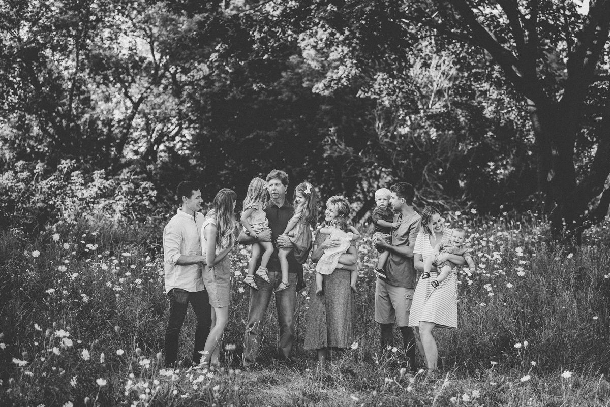 Group gathered outdoors for a candid photo among blooming wildflowers.