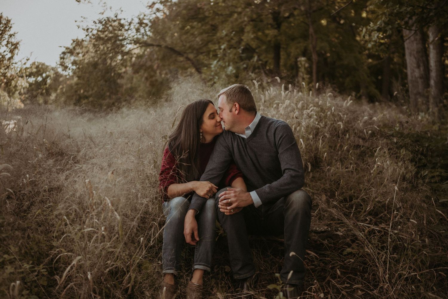 A romantic outdoor portrait captured during golden hour showing a tender moment between a couple.