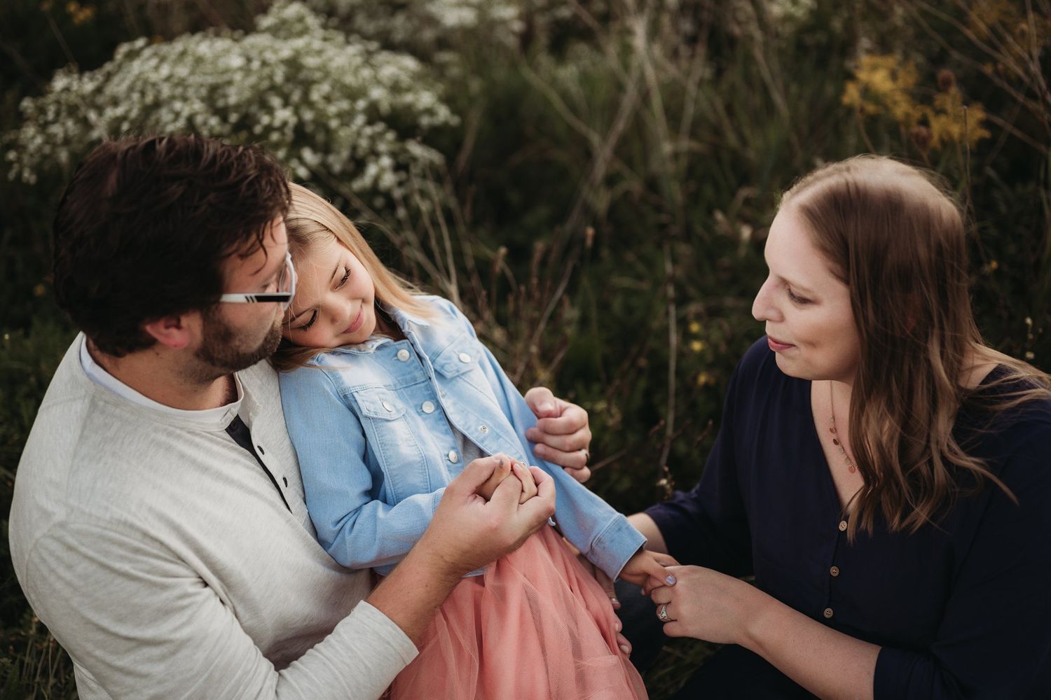 Candid family moment captured during outdoor photo session in natural setting.
