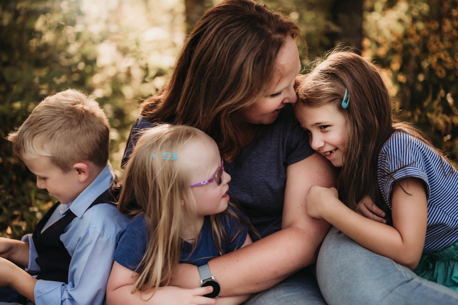 A warm family moment captured as they share embraces on a blanket outdoors.