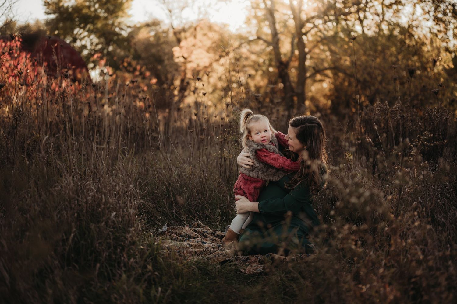 Joyful interaction between parent and child in autumn field.