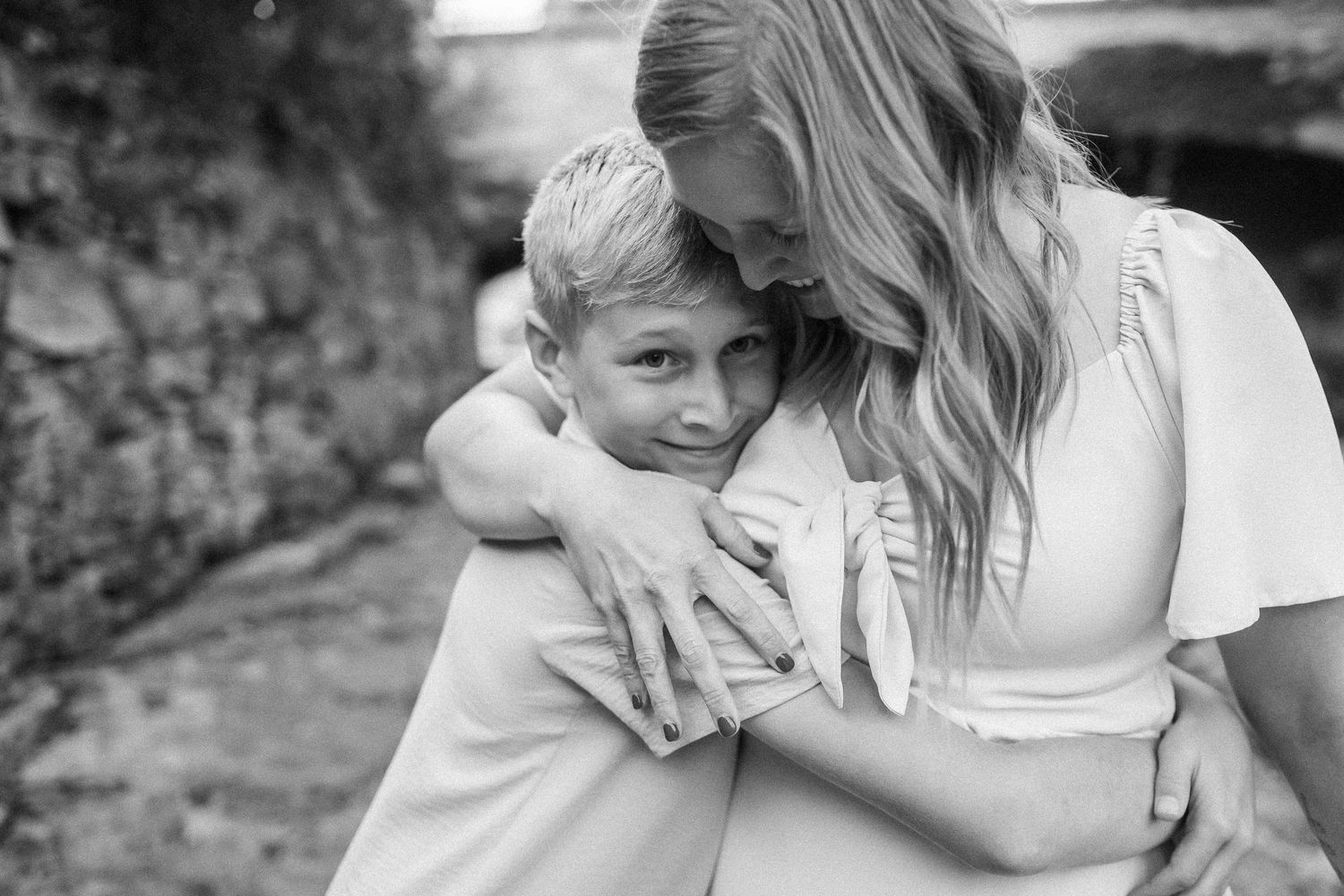 Black and white series of intimate candid moments showing affectionate interactions outdoors.