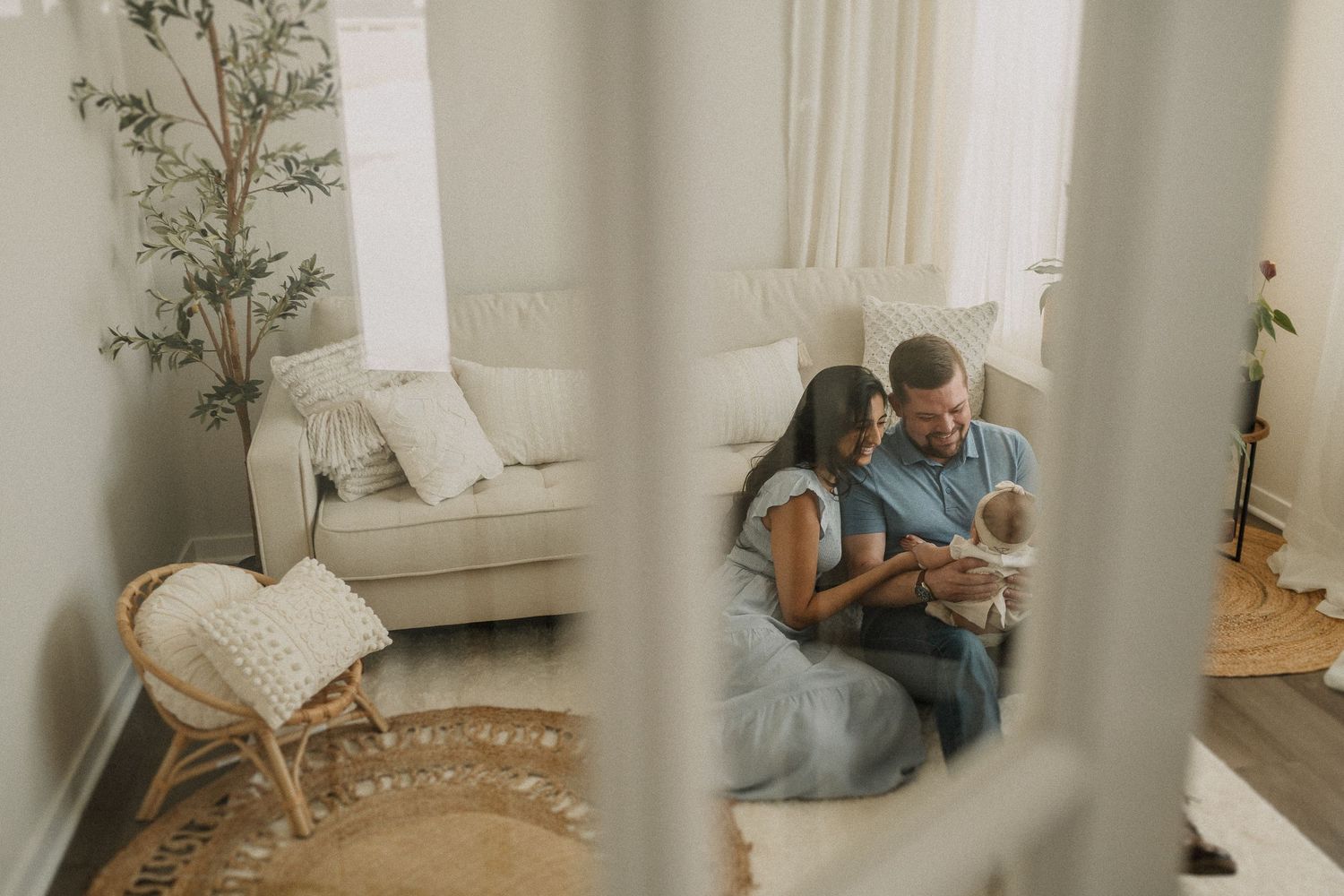 Intimate indoor family scene viewed through window frame with soft natural lighting.