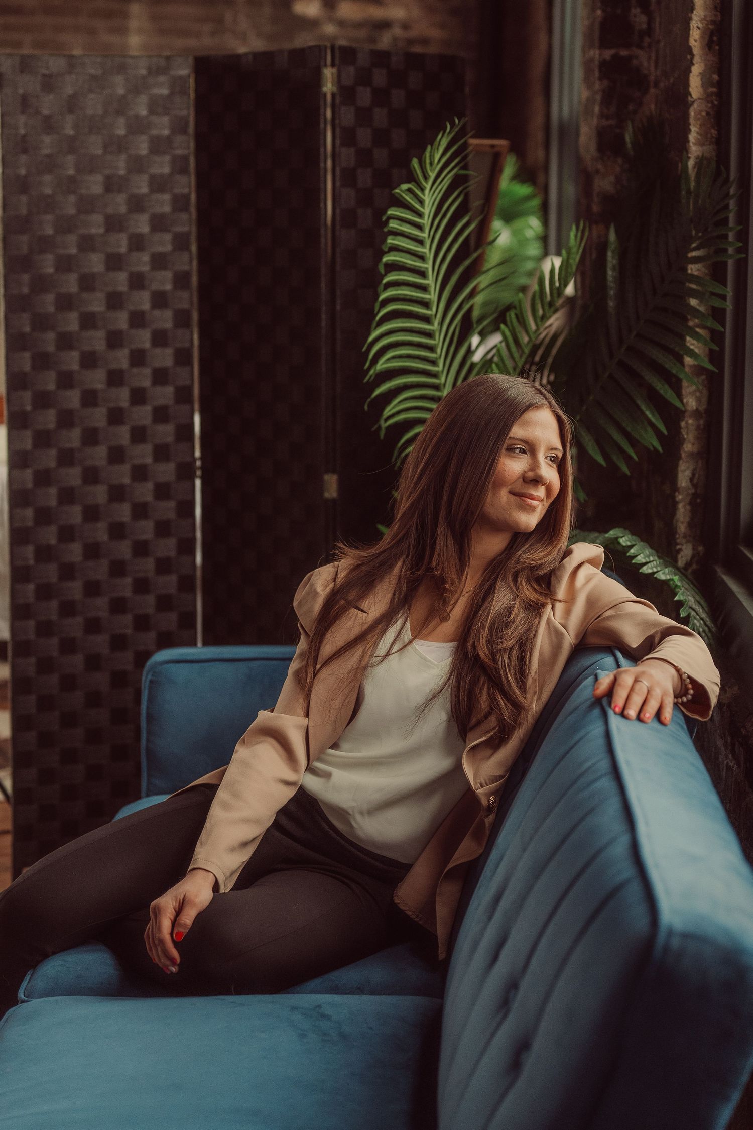 Relaxed lifestyle photo on a blue couch with plants and natural window light.