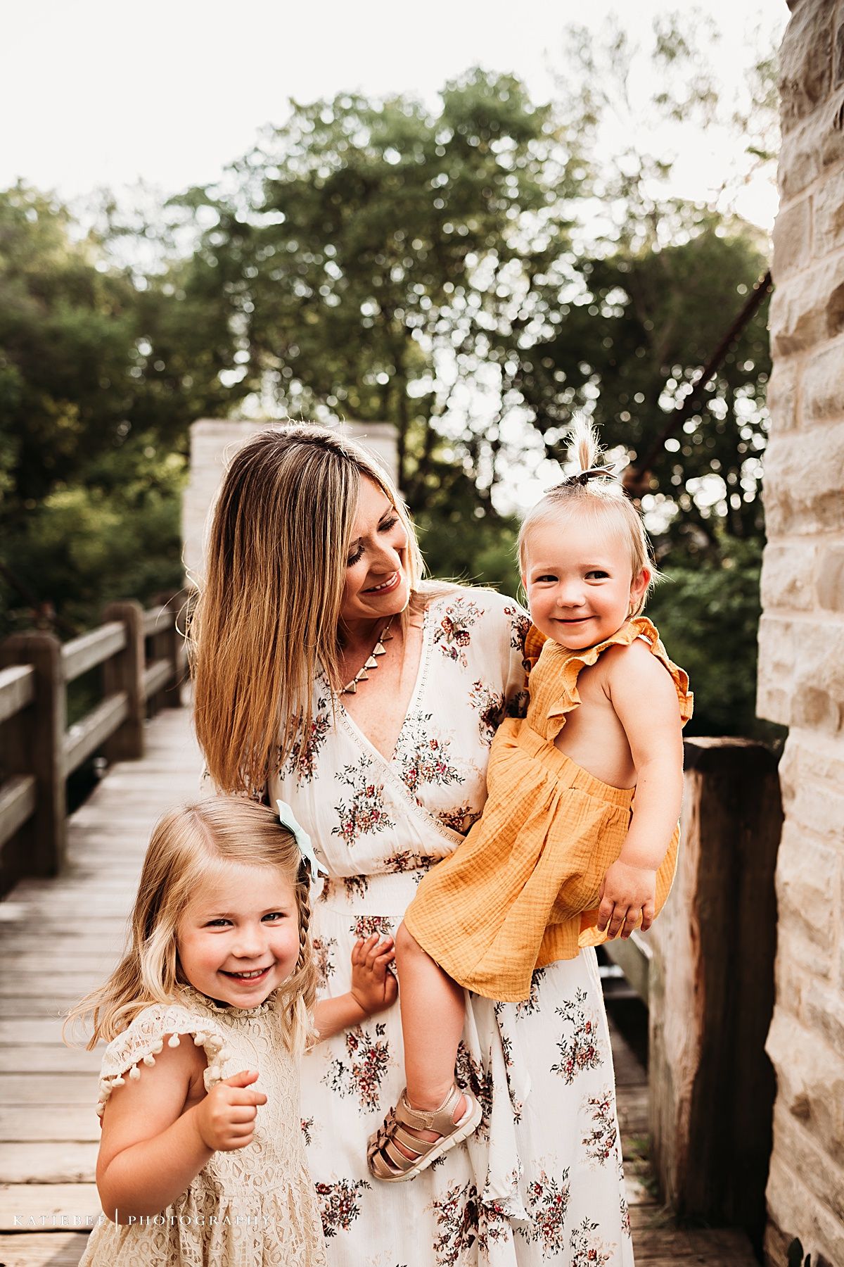 Joyful family moment captured on wooden bridge during golden hour.