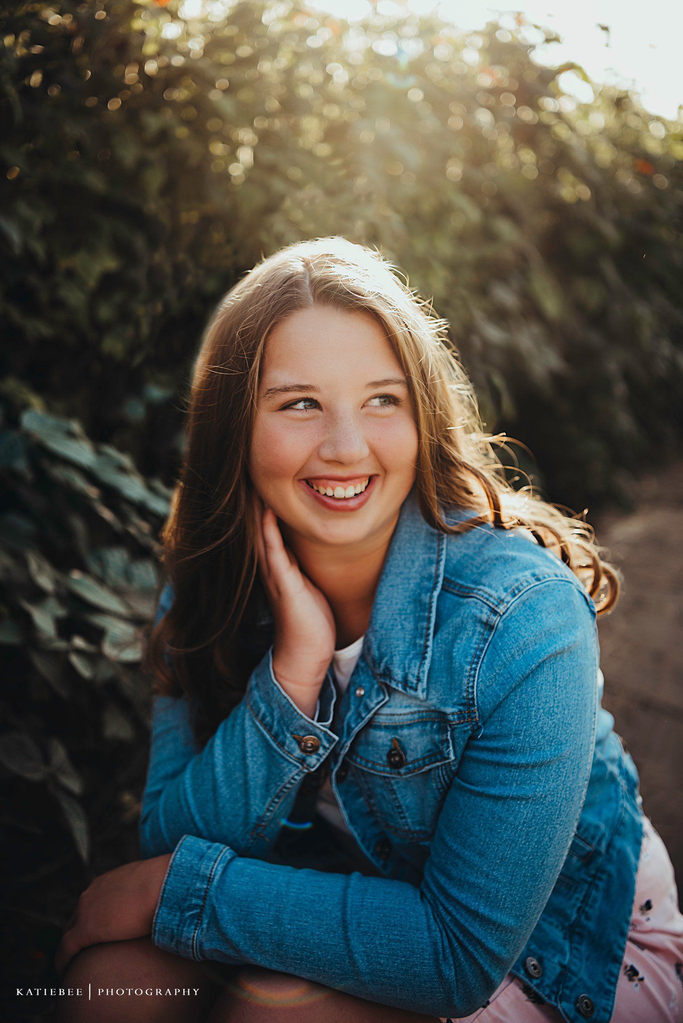 Close-up portrait with natural lighting and greenery in background.