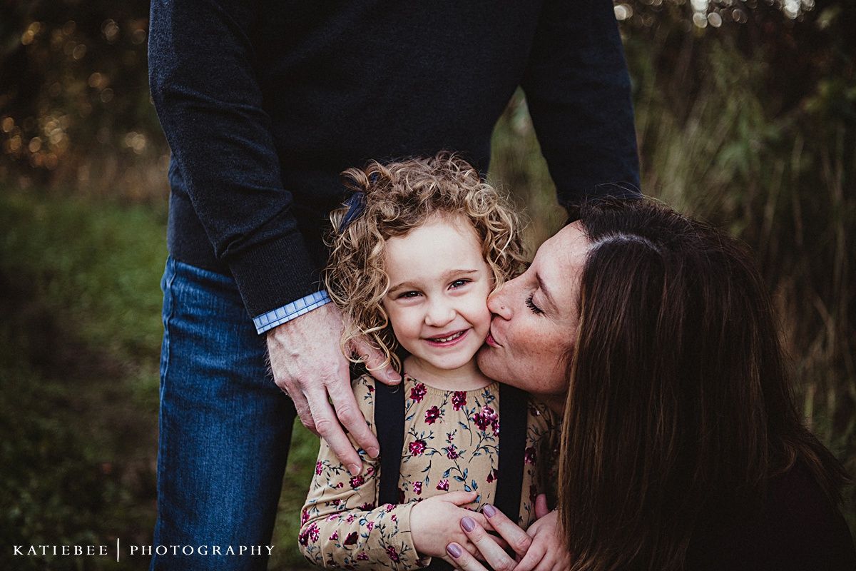 A tender moment captured between parent and child amid autumn foliage.