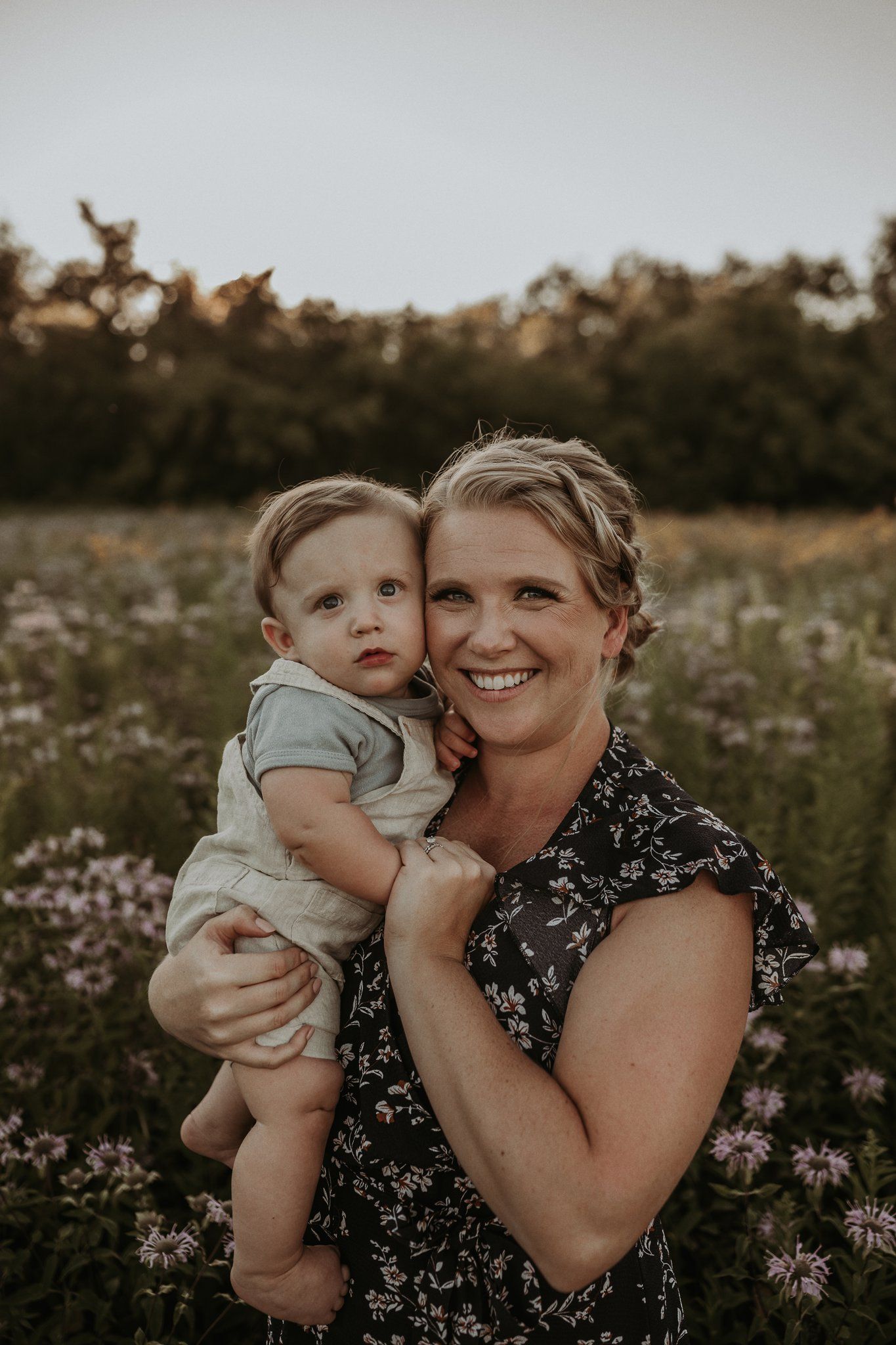 Natural family portrait in wildflower meadow during golden hour.