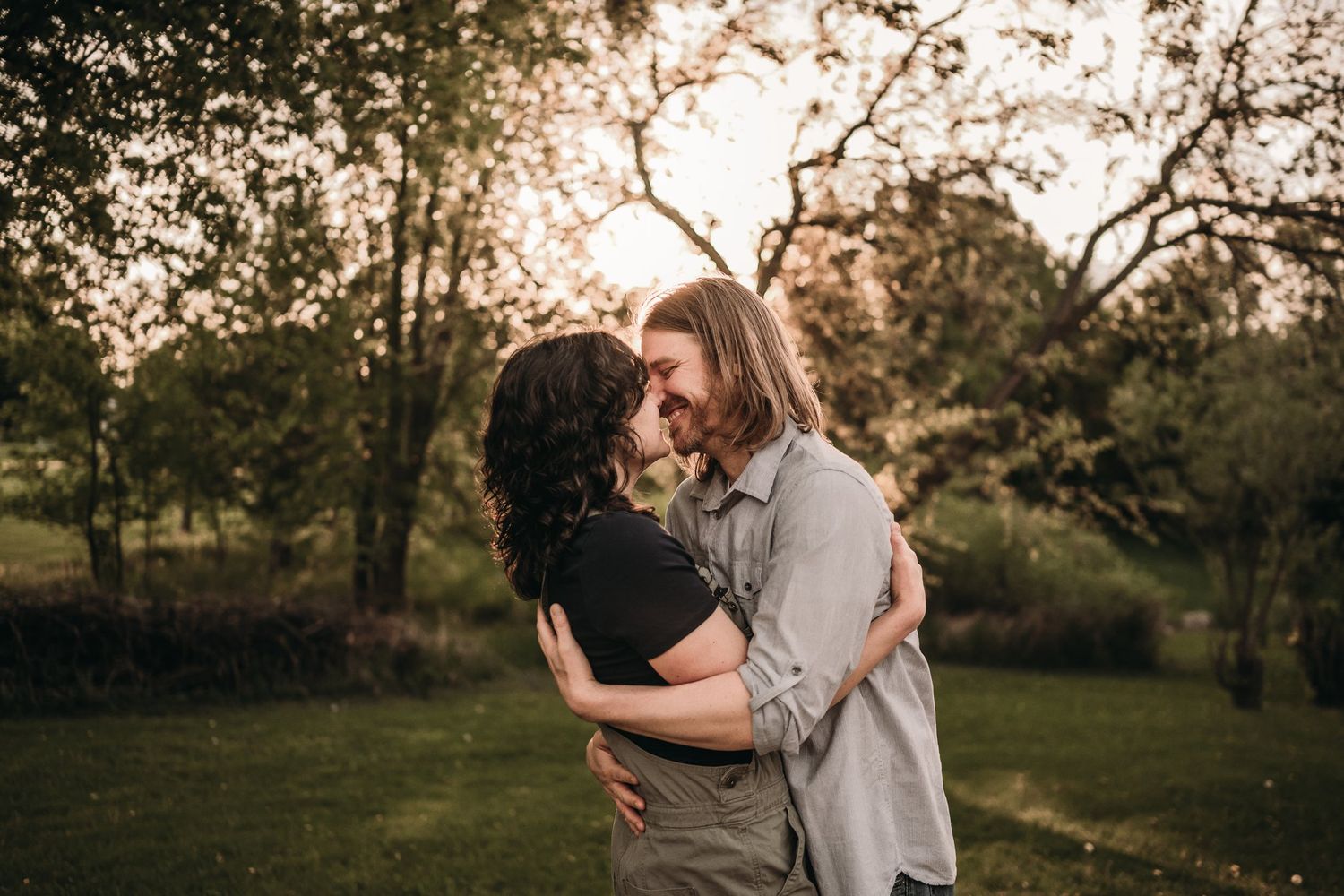 Couple embracing in a serene garden setting during golden hour.