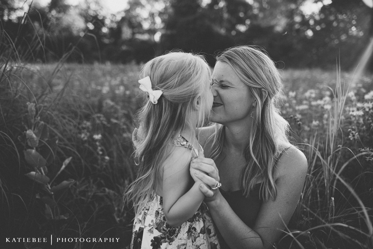 Intimate black and white portrait in a wild grass field with soft natural lighting.