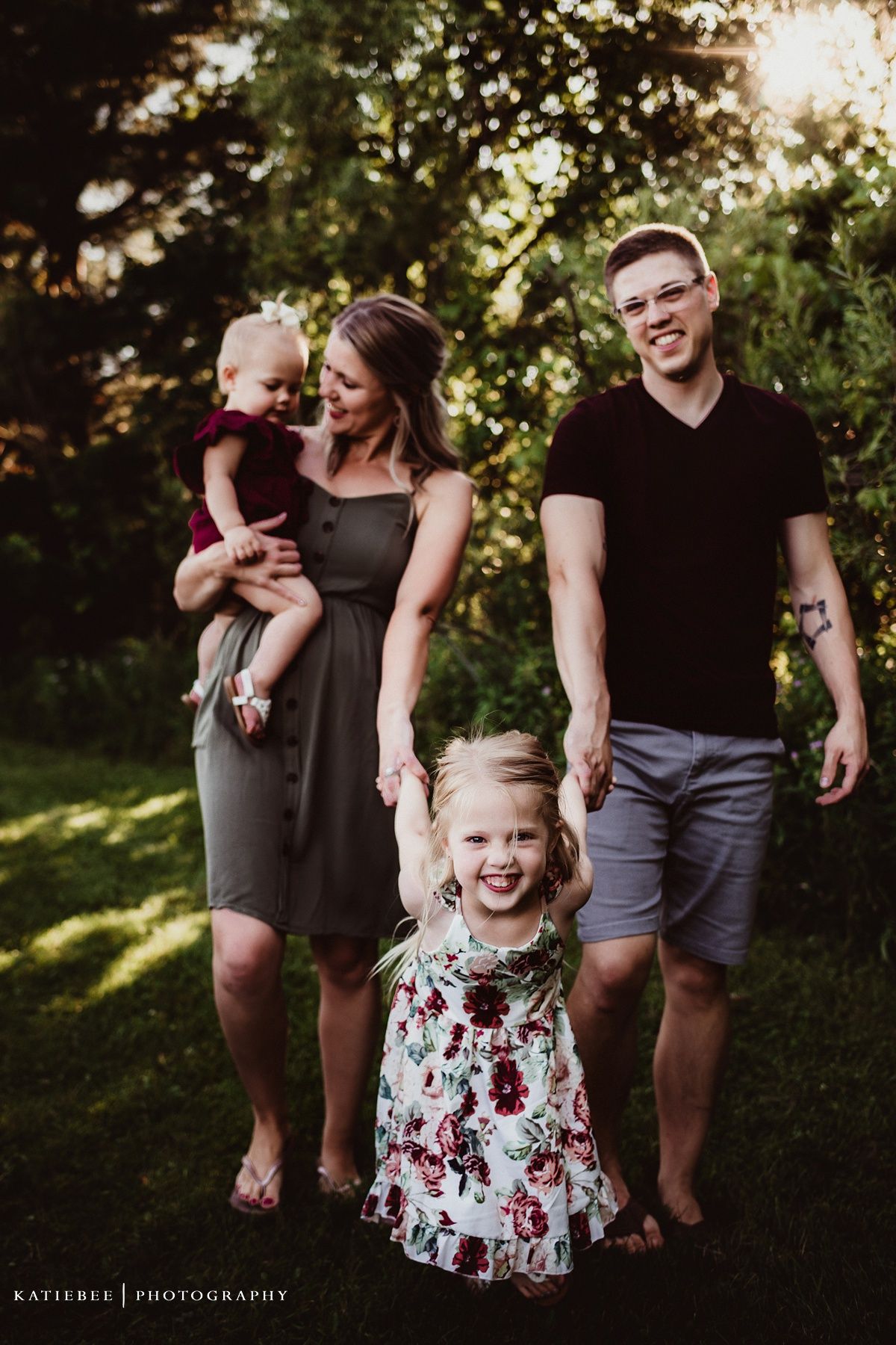 Casual outdoor family portrait in a backyard garden with natural sunlight.