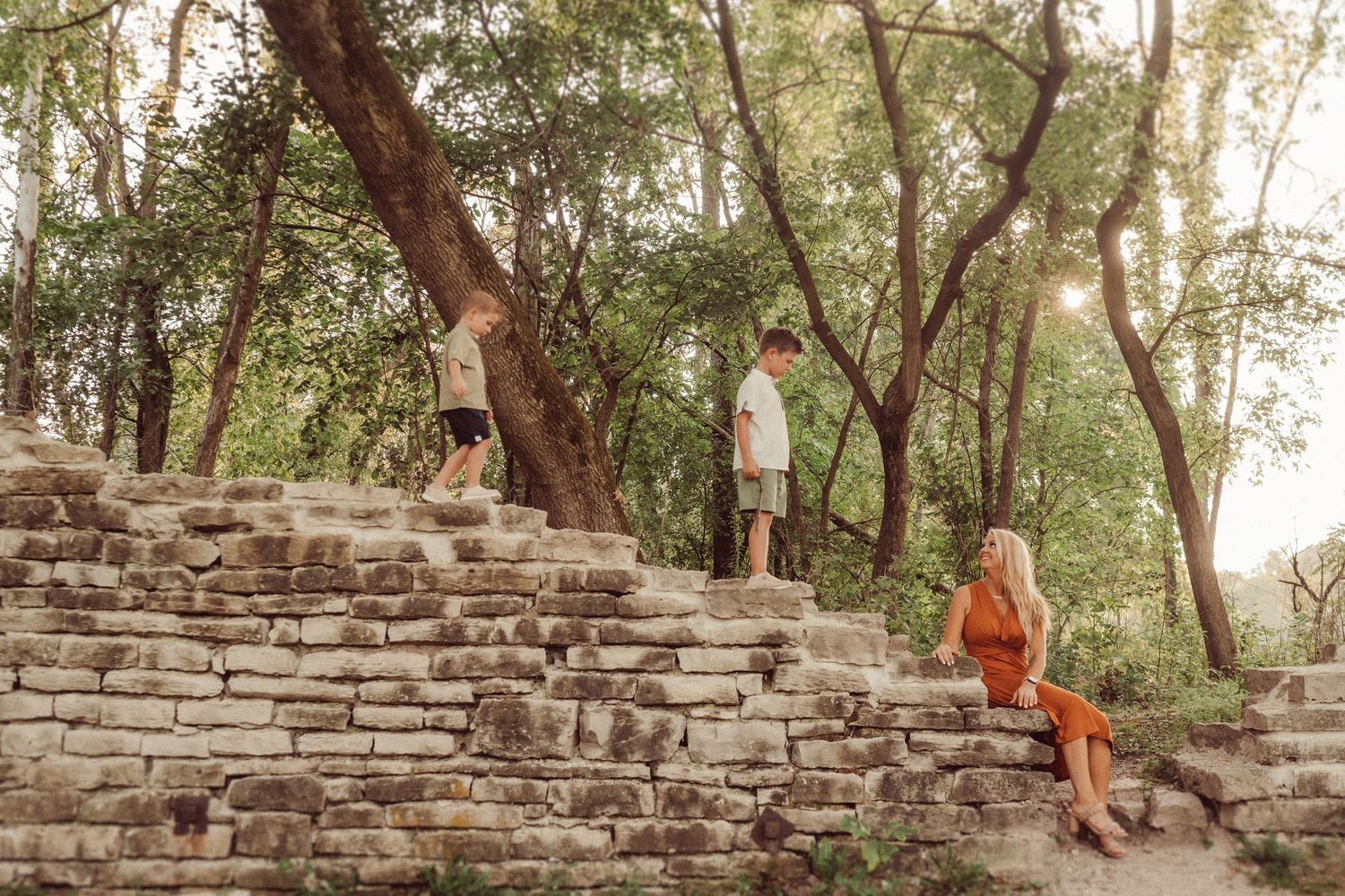 Stone steps wind through wooded area as people explore natural setting.