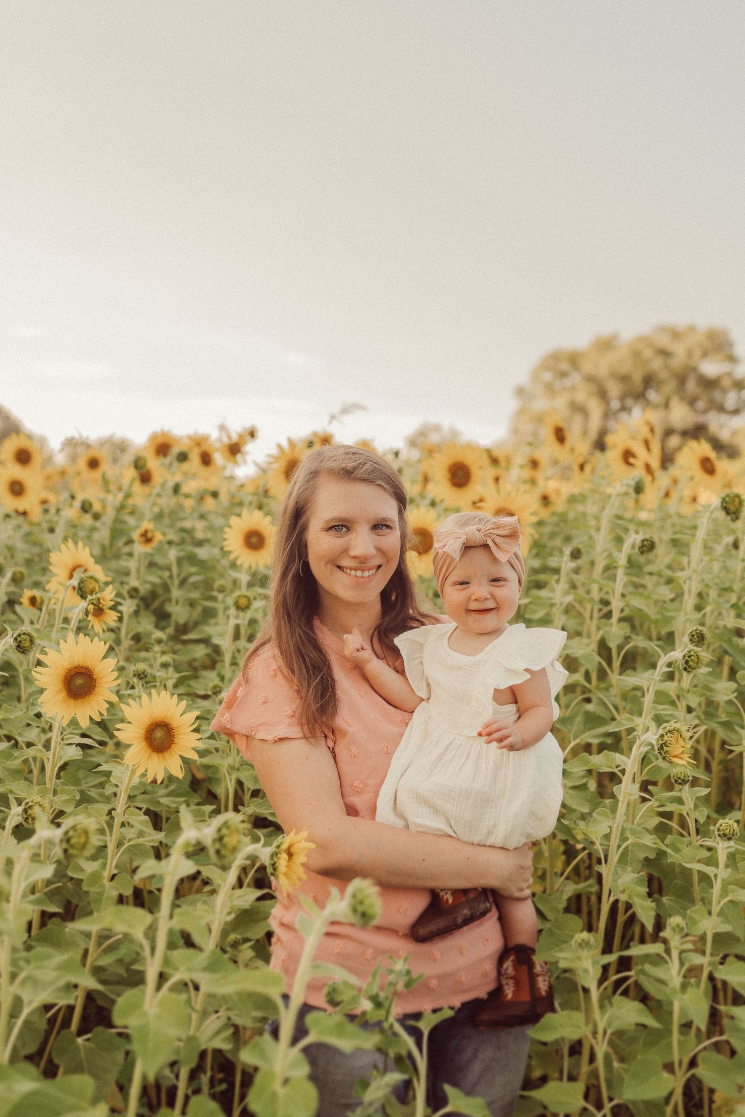 A heartwarming moment captured in a sunflower field during golden hour.