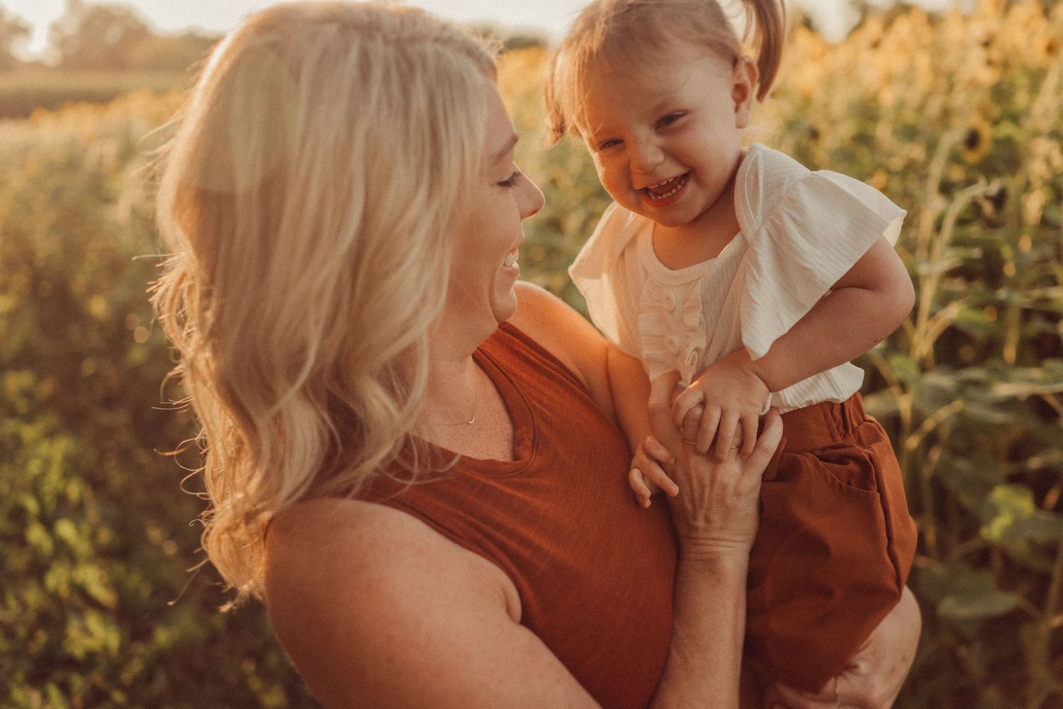 Joyful interaction captured during sunset in a field of blooming sunflowers.