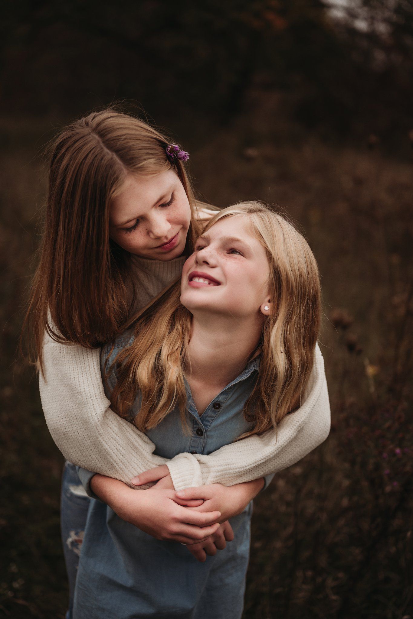 An intimate moment captured between two people embracing and smiling in a natural outdoor setting.