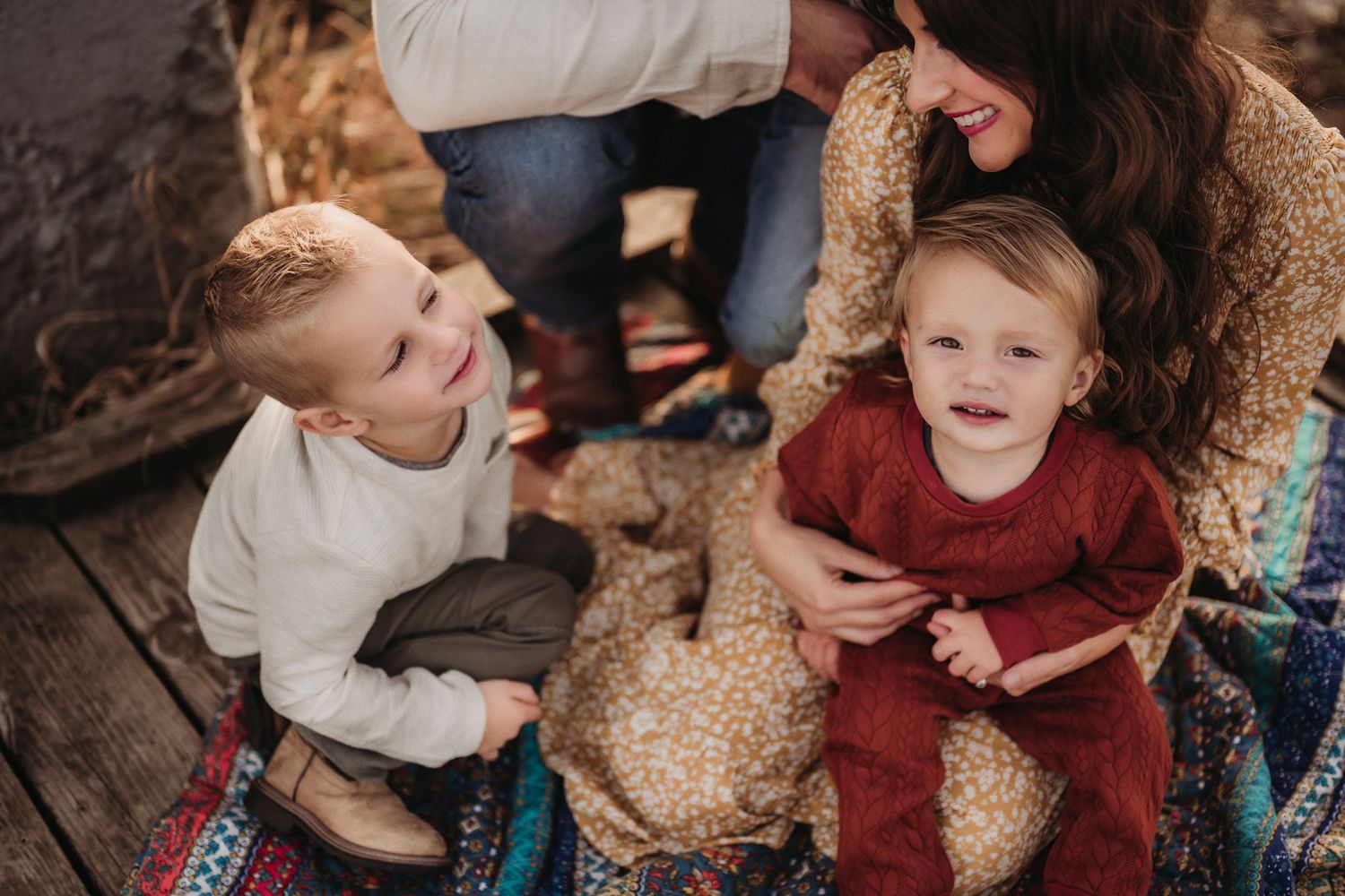 Two young children sharing playful moment during outdoor family photoshoot.