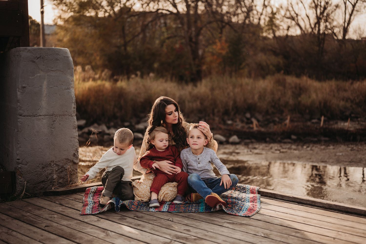 A group sits together on a wooden dock during golden hour.
