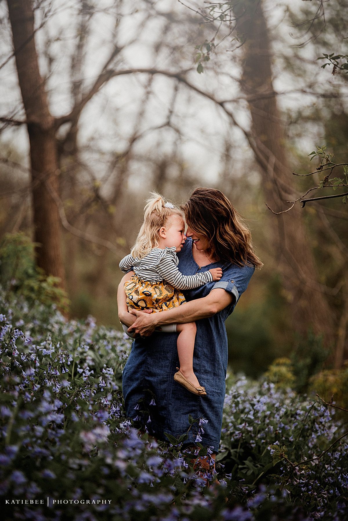 A heartwarming moment among purple wildflowers with denim and striped clothing.