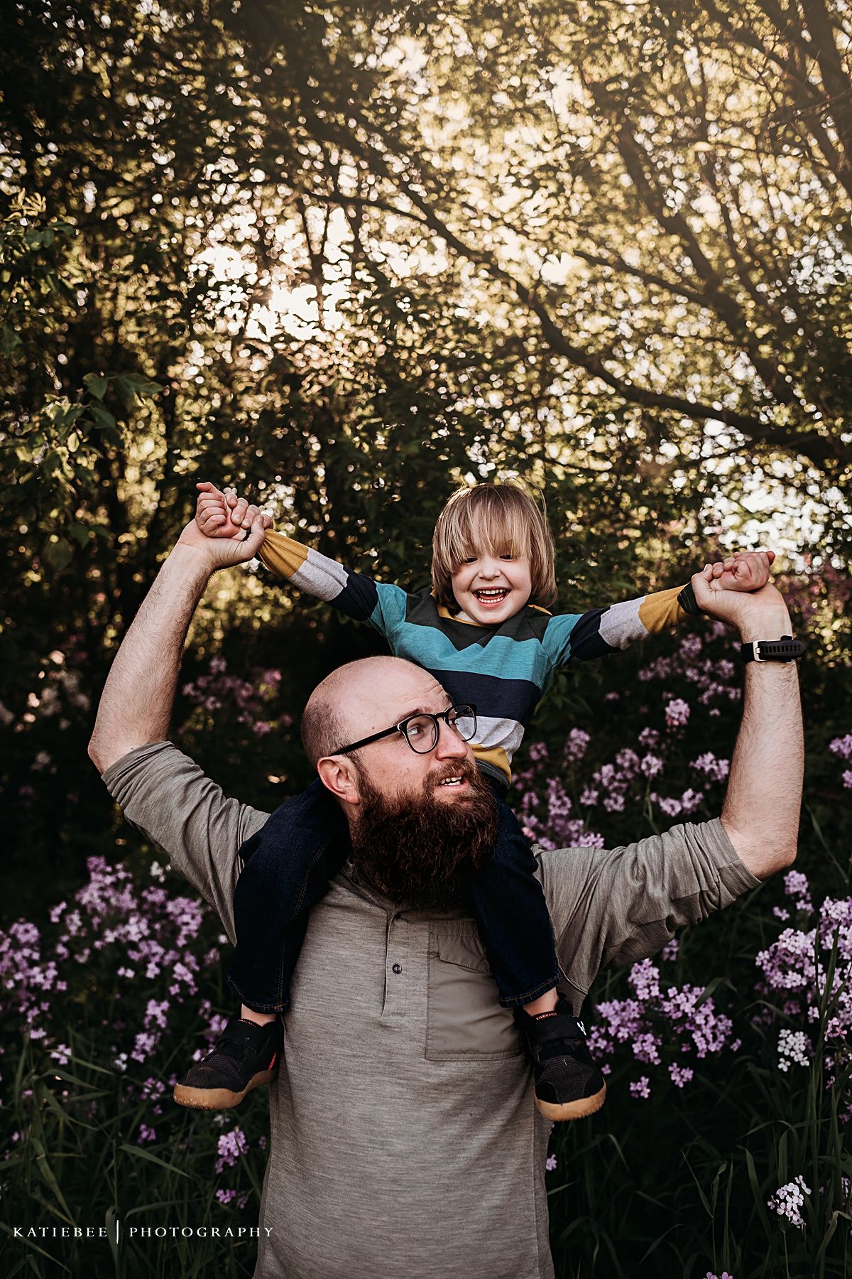 Joyful moment captured at sunset with playful poses amongst purple wildflowers in a natural outdoor setting.