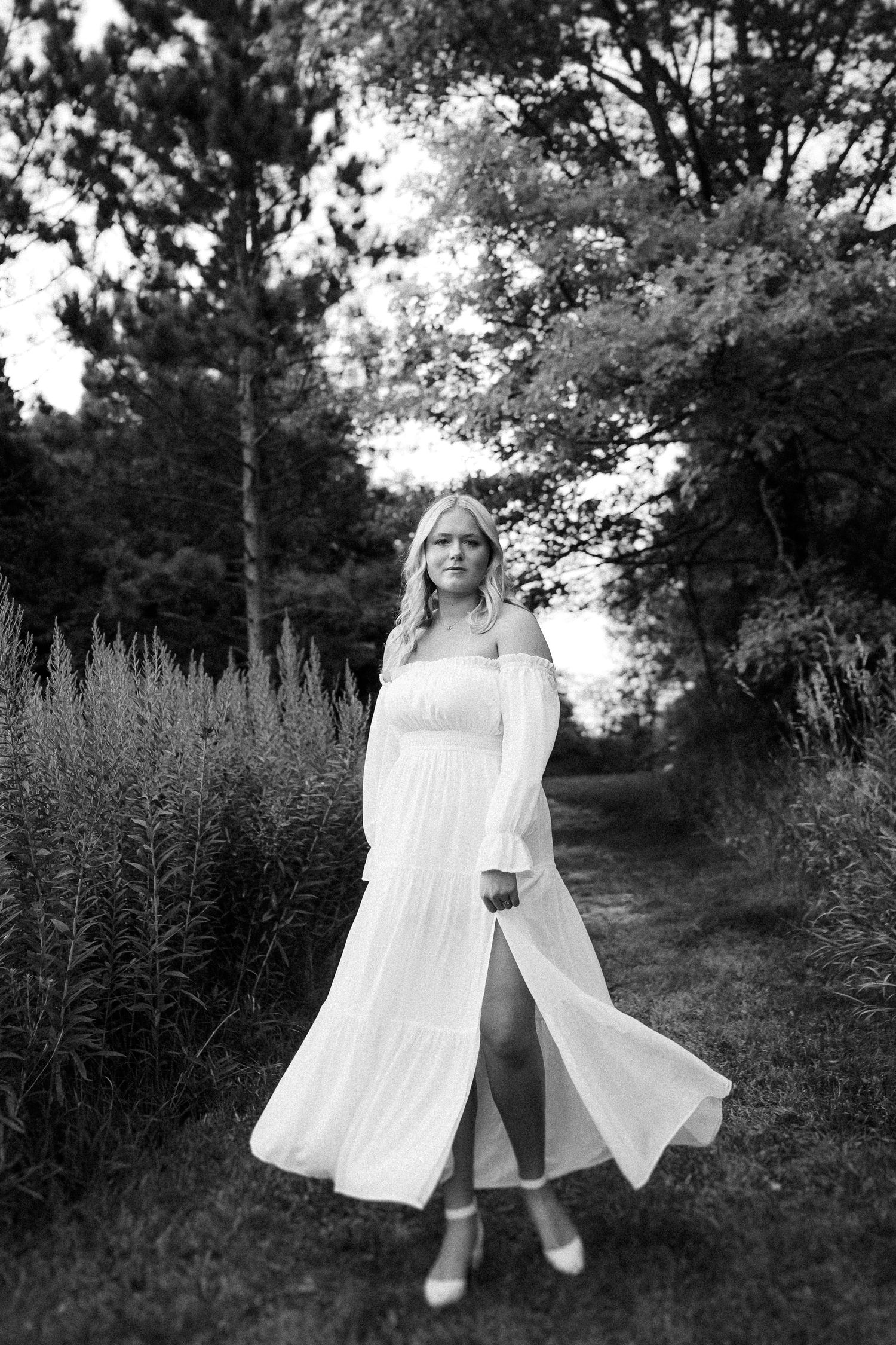 A figure in flowing white clothing moving gracefully through a wooded path.