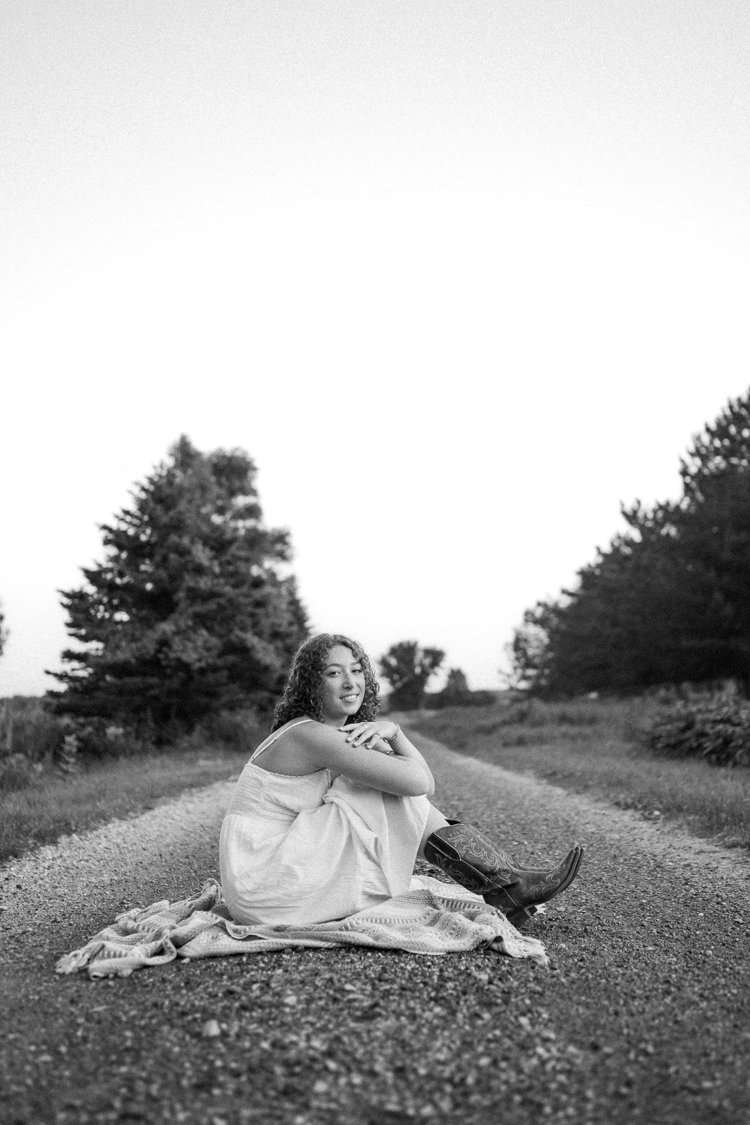 Artistic black and white portraits showing someone reclining on a rural gravel path.