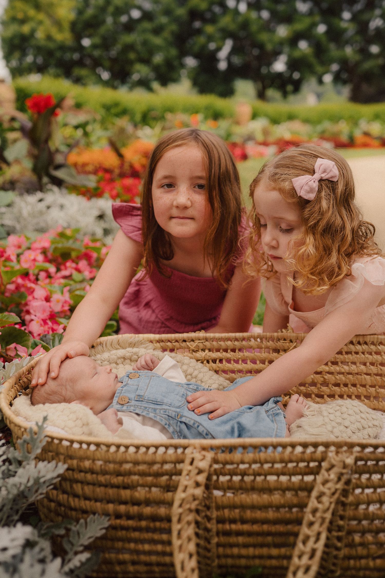 Tender family interactions captured on a woven wicker bench surrounded by colorful flowers.