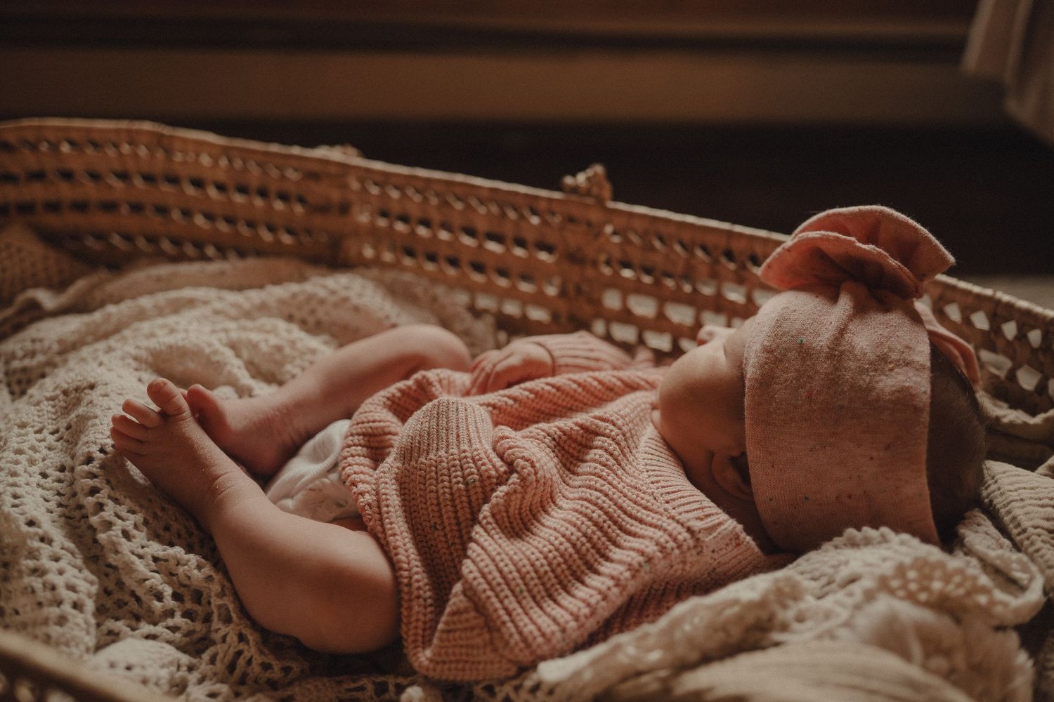 Close-up view of soft pink knit fabric in warm, ambient lighting.
