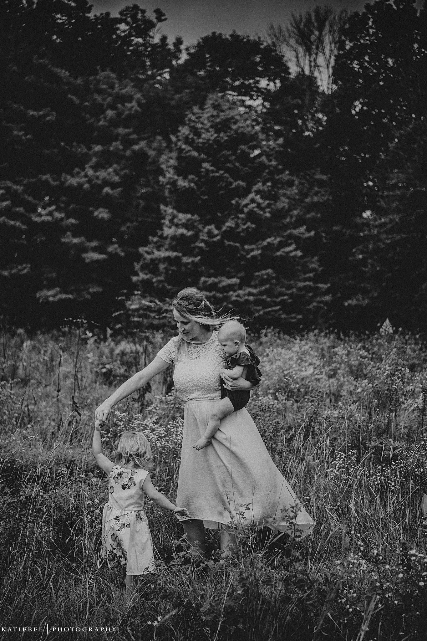 A whimsical black and white portrait of dancing together in a summer meadow.
