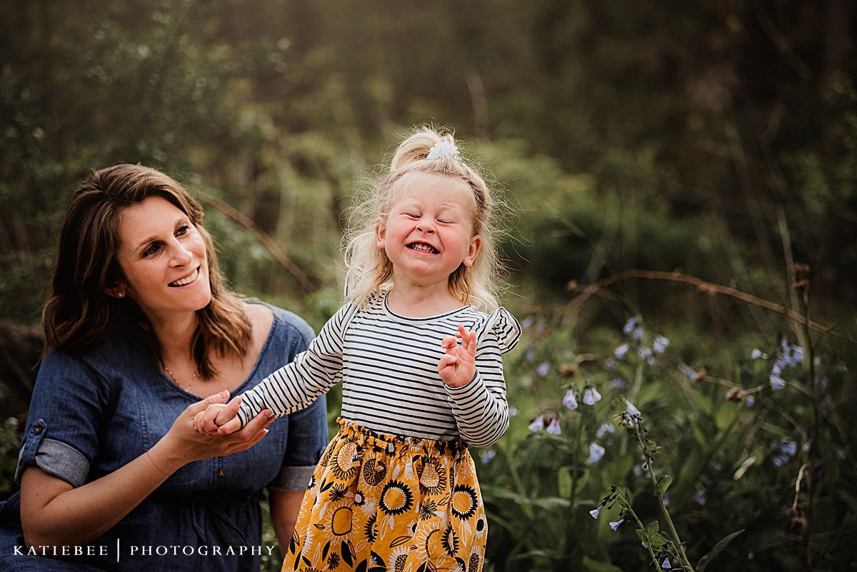 A candid moment of pure joy and laughter captured between two people in a field of flowers.