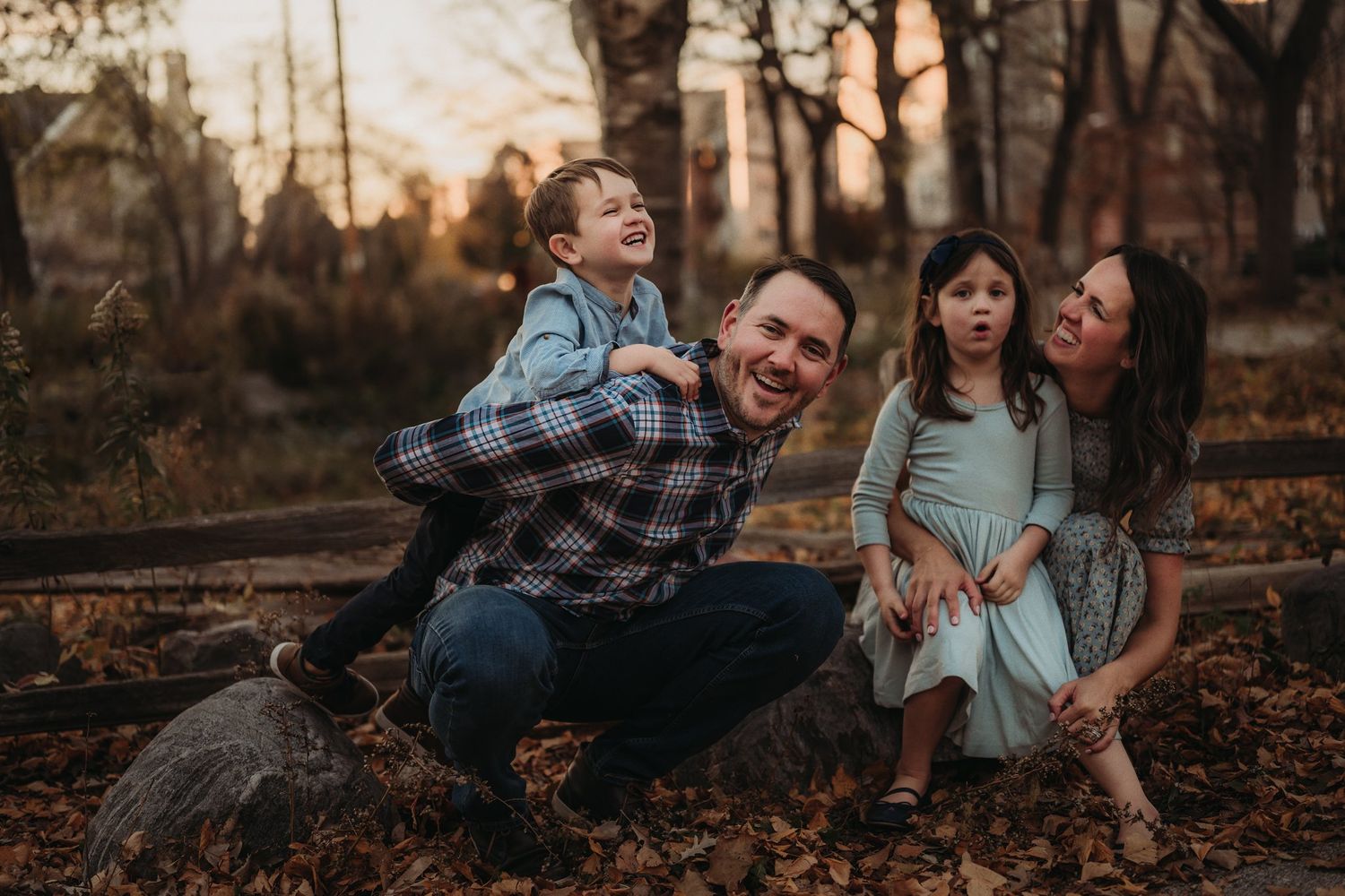 A playful autumn family photo session with everyone laughing together outdoors.