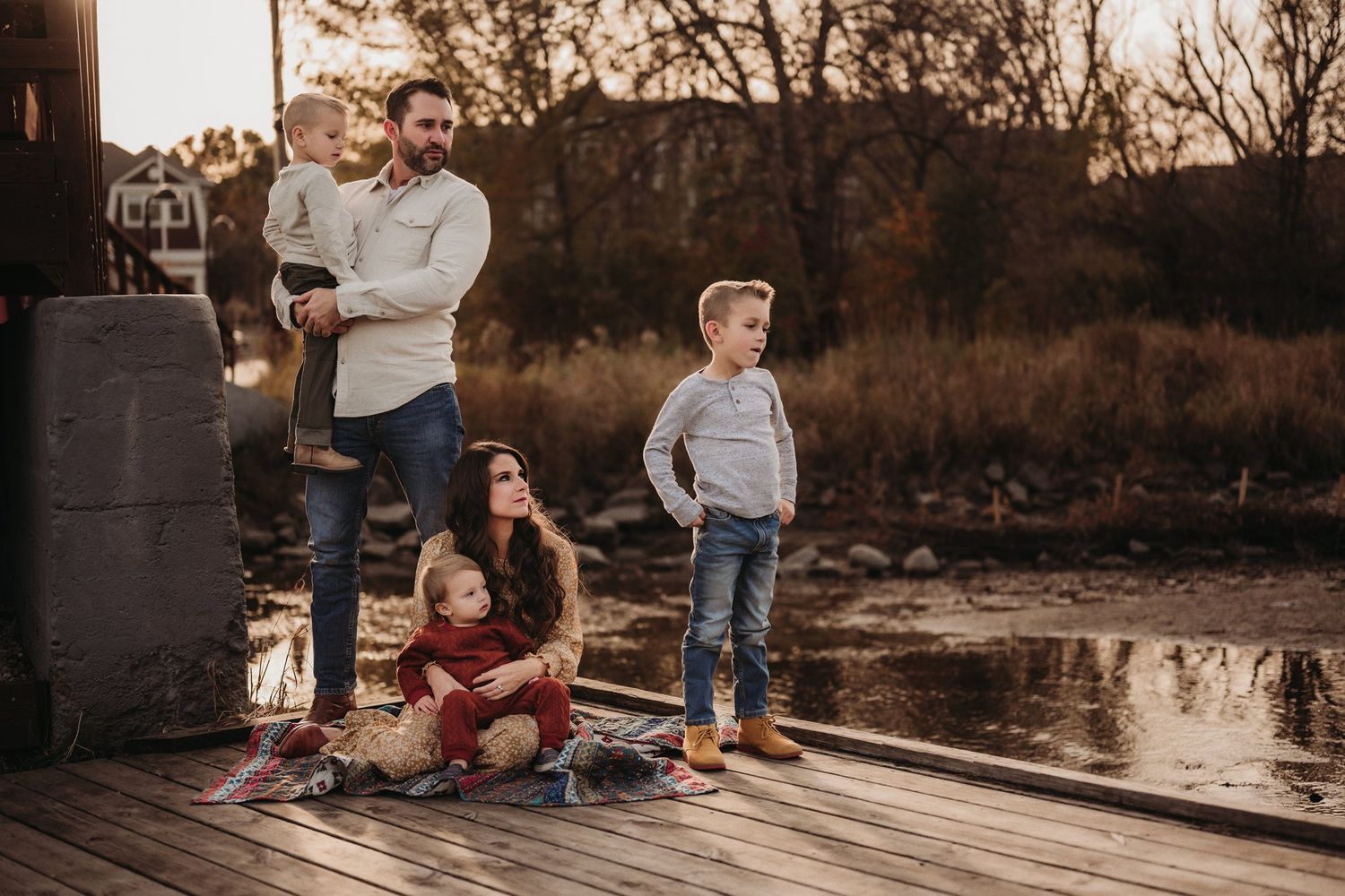 Family lifestyle portrait on wooden deck during golden hour.