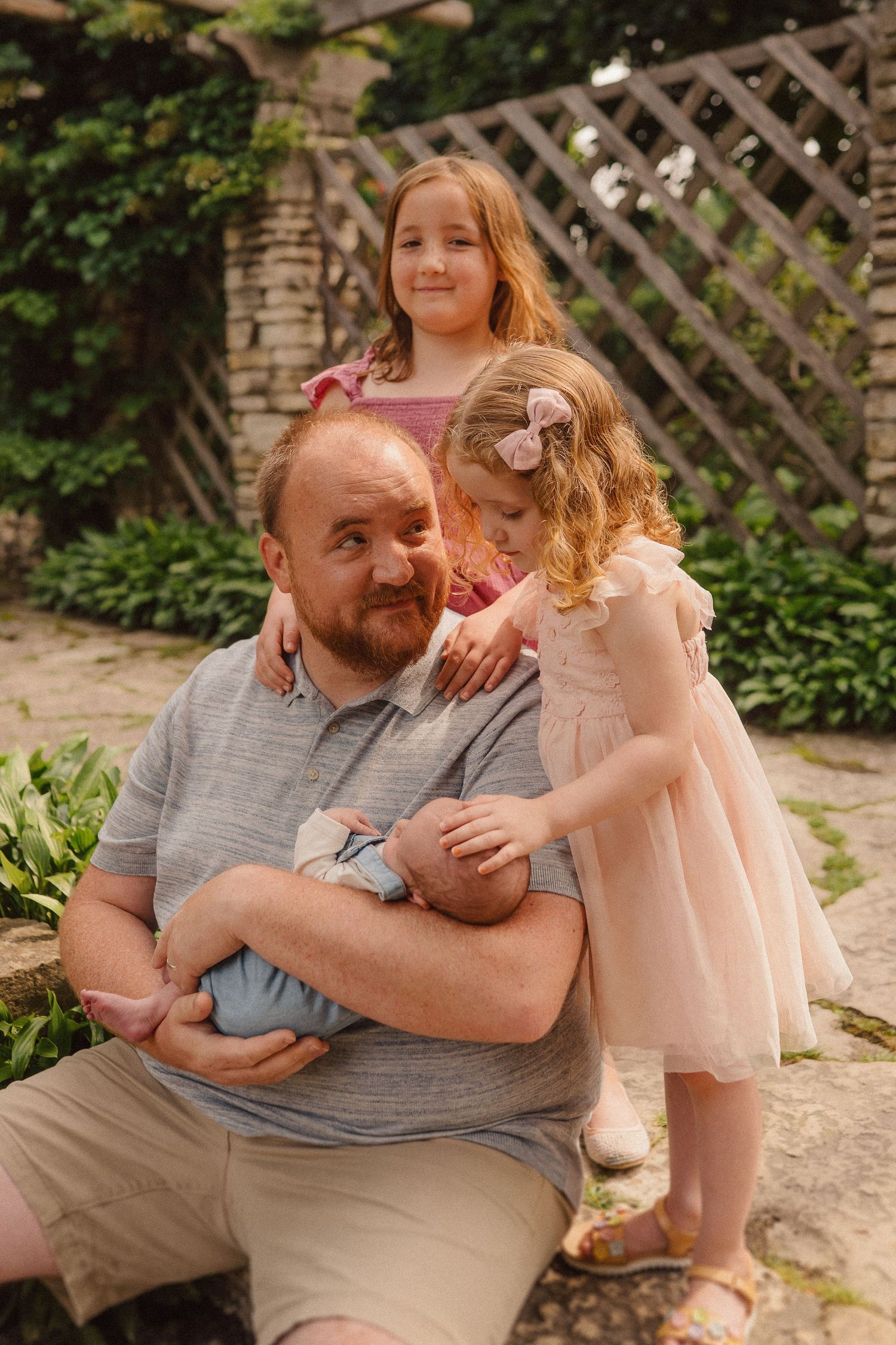 Heartwarming series of moments between a father and daughter sharing hugs and laughter in a garden setting.