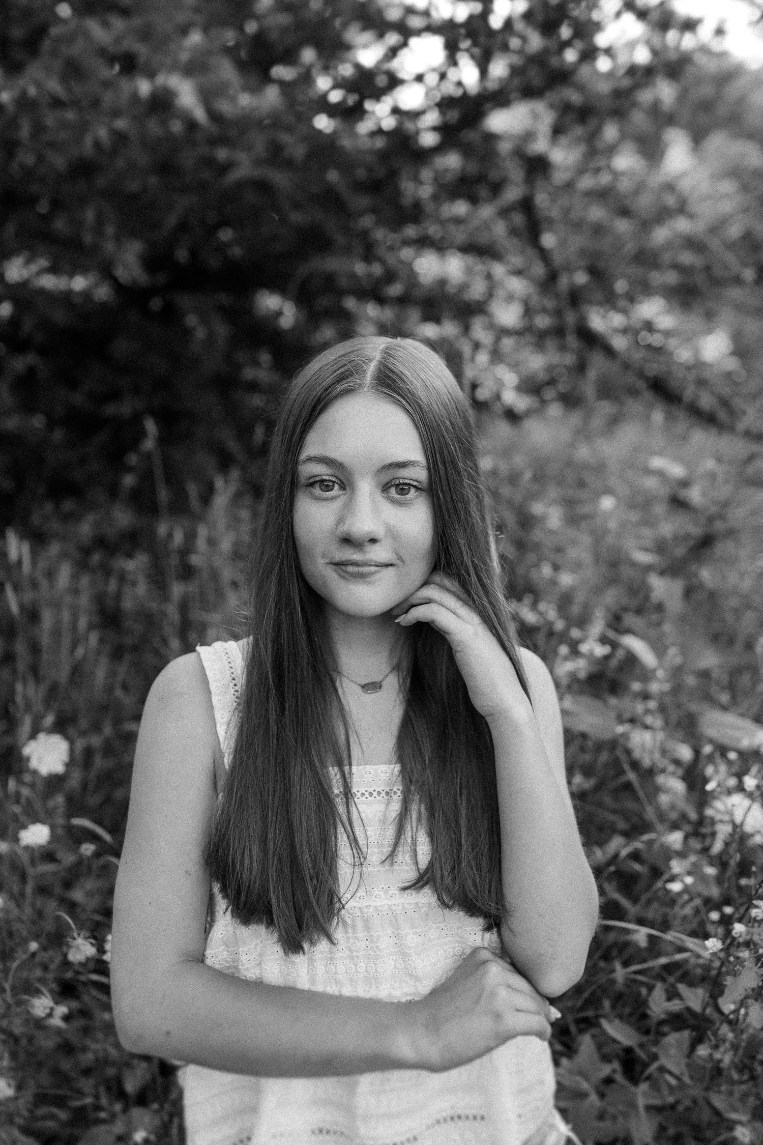 Black and white portrait series showing a person in a white sleeveless top against a natural outdoor backdrop.